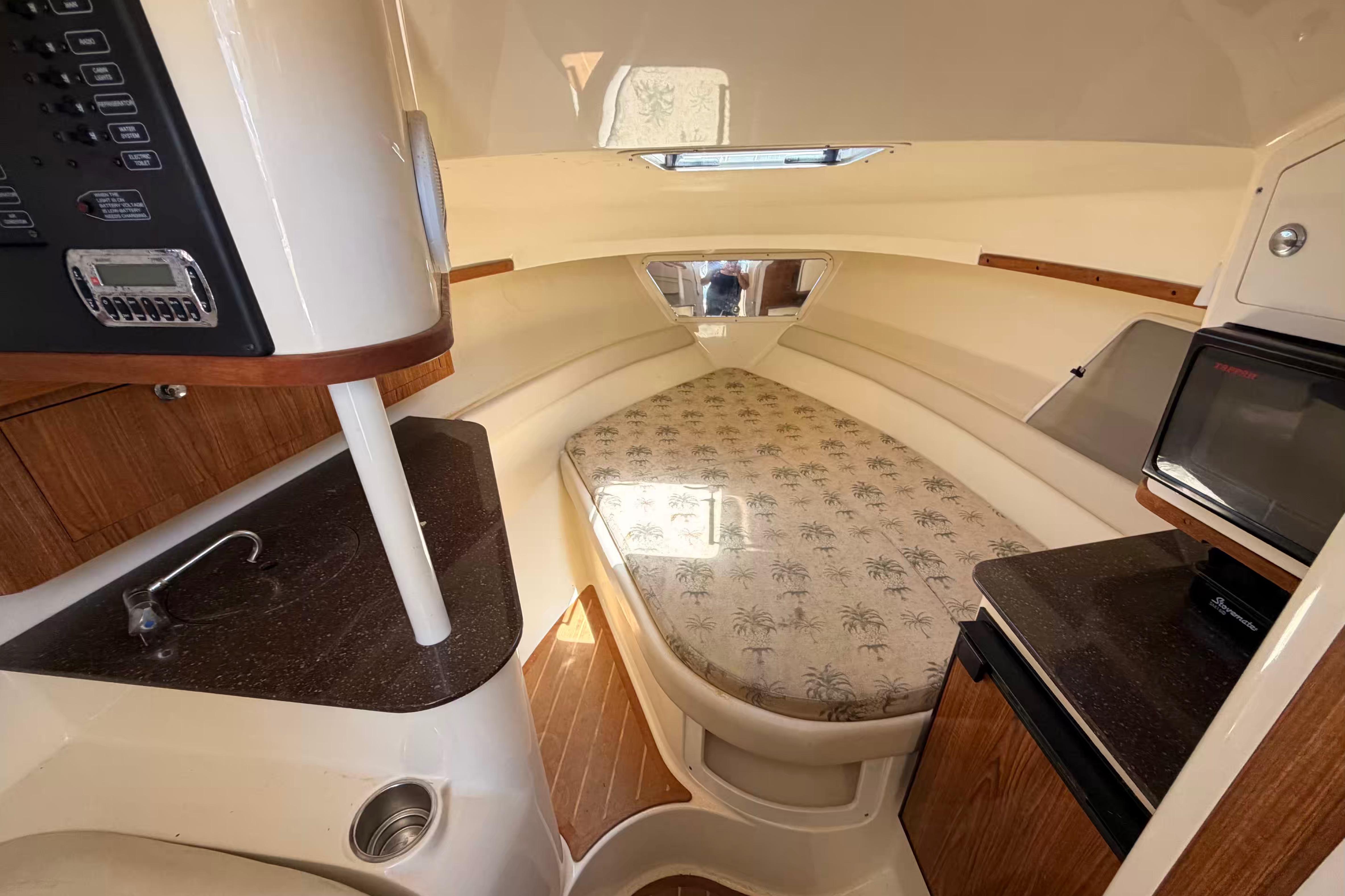 2007 Scout 262 Abaco cabin interior with bed, kitchenette, and control panel.