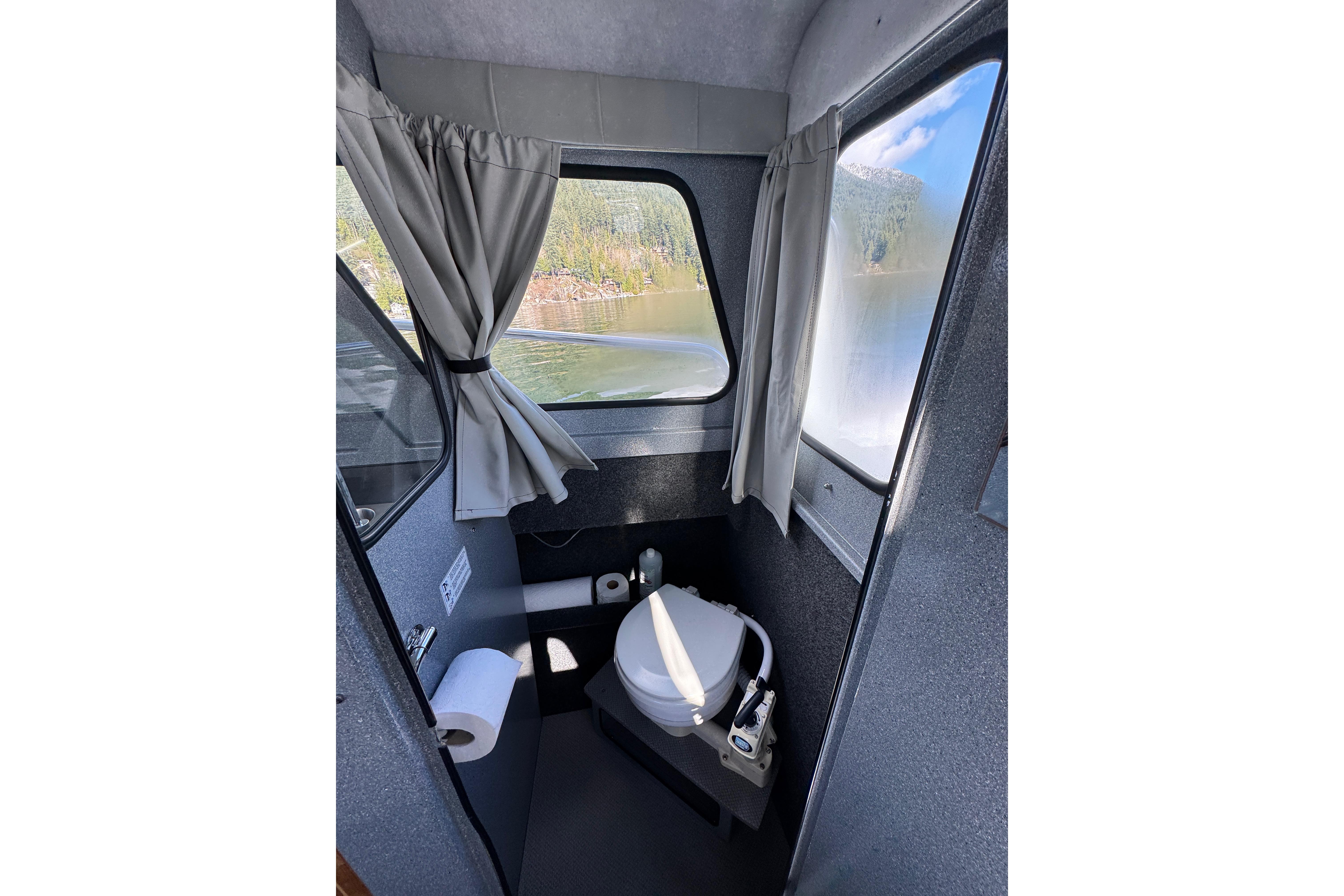 Interior of 2018 KingFisher 2725 Weekender boat with compact bathroom.