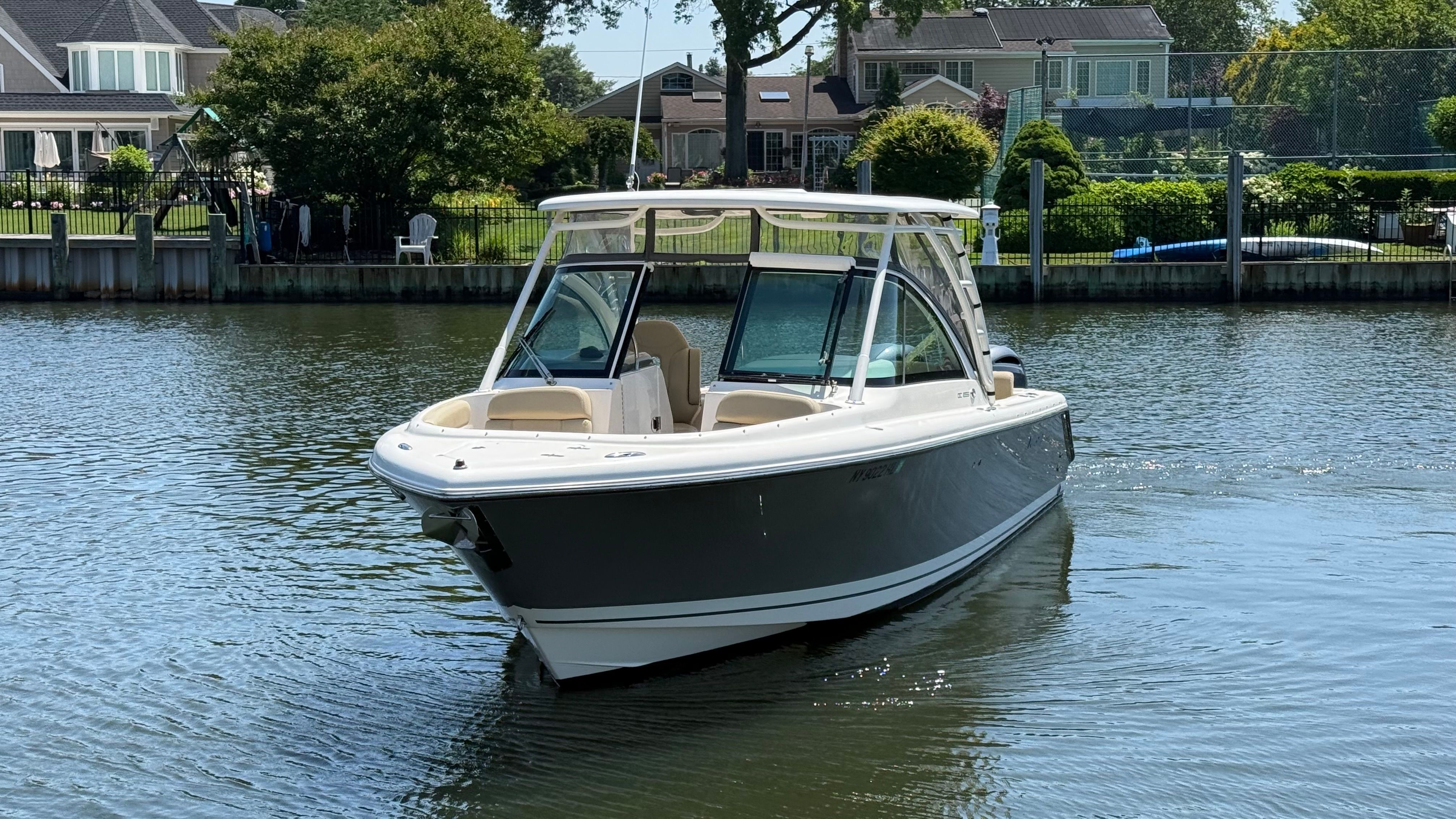A 2016 Pursuit DC 265 Dual Console boat cruising on calm water.