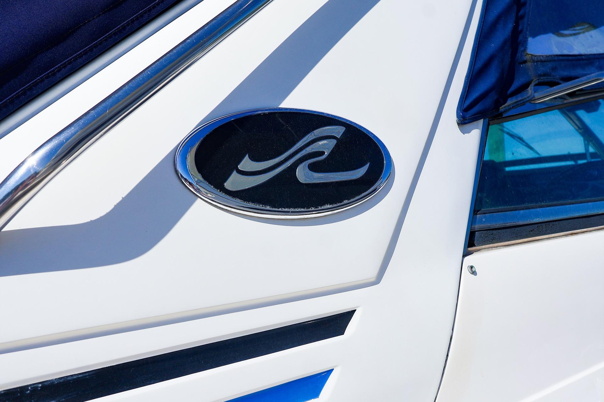 Close-up of 1998 Sea Ray 500 Sundancer logo on white boat exterior.