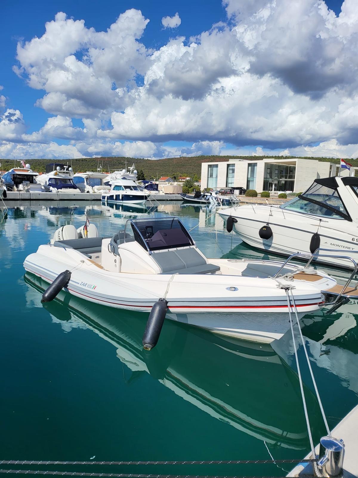 2020 Zar 85 SL boat docked in a marina under a partly cloudy sky.