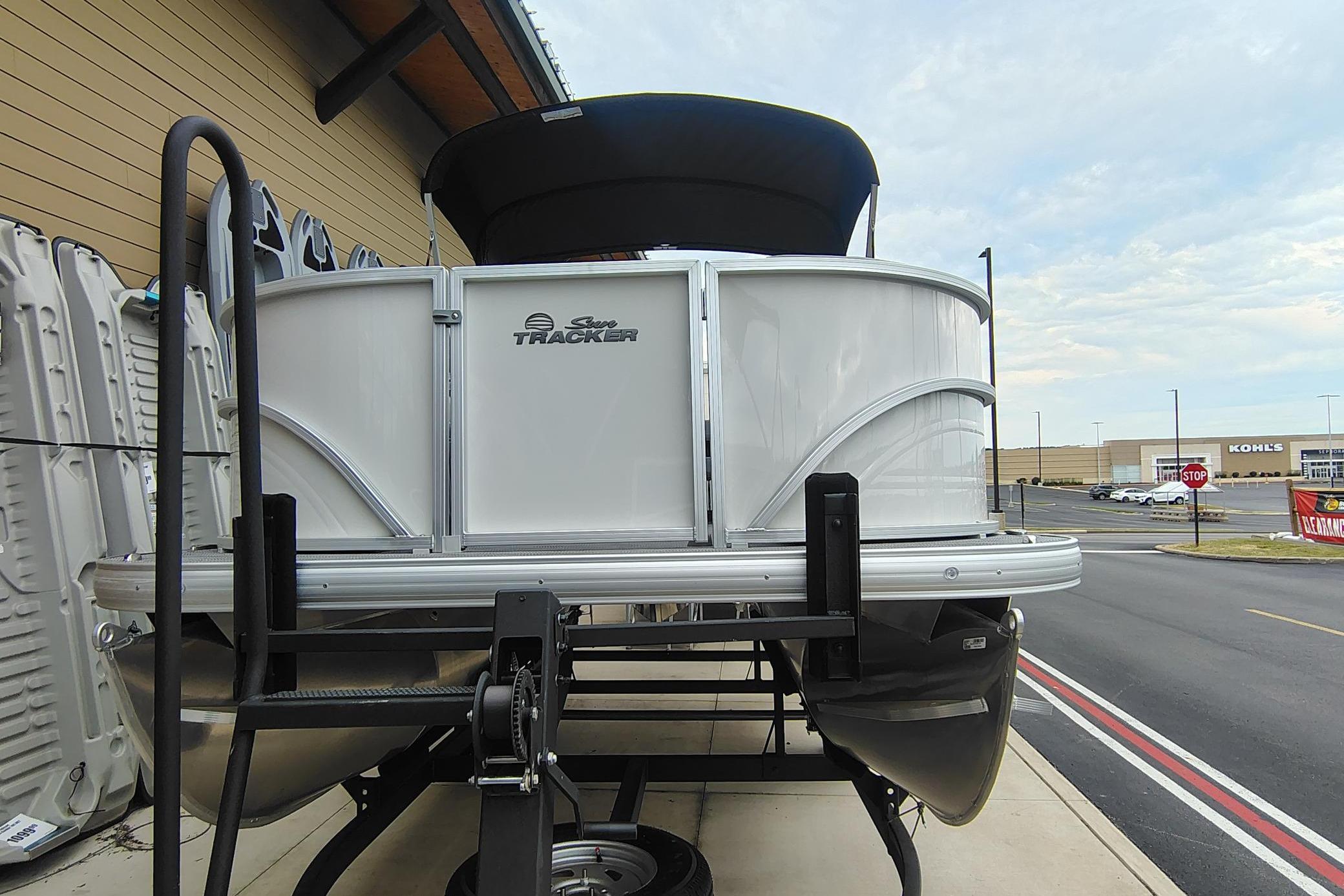 2026 Sun Tracker Party Barge 16 DLX pontoon boat on trailer, parked outdoors.