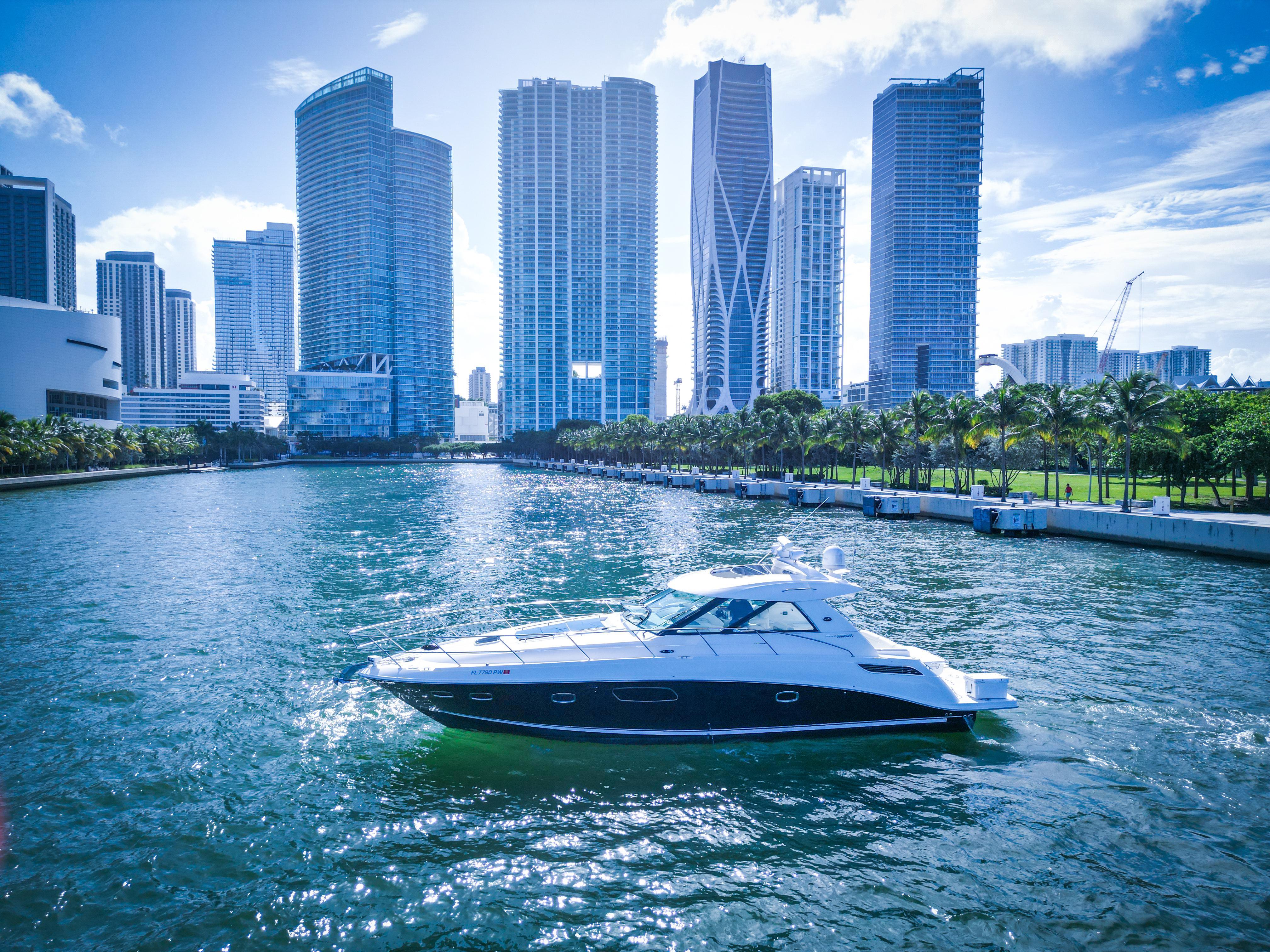 Sea Ray 450 Sundancer 2010 yacht cruising near city skyline.