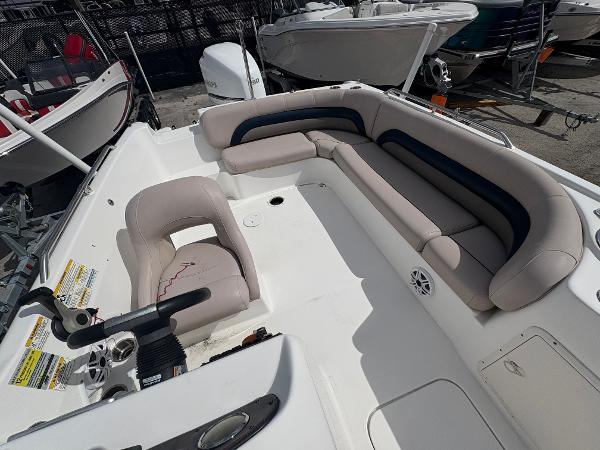 2014 Hurricane SunDeck Sport 232 OB boat interior with seating and steering console.