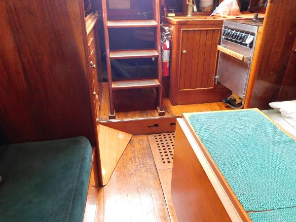 Interior of 1983 Custom Murray Peterson Coaster III boat with wooden furnishings and stairs.
