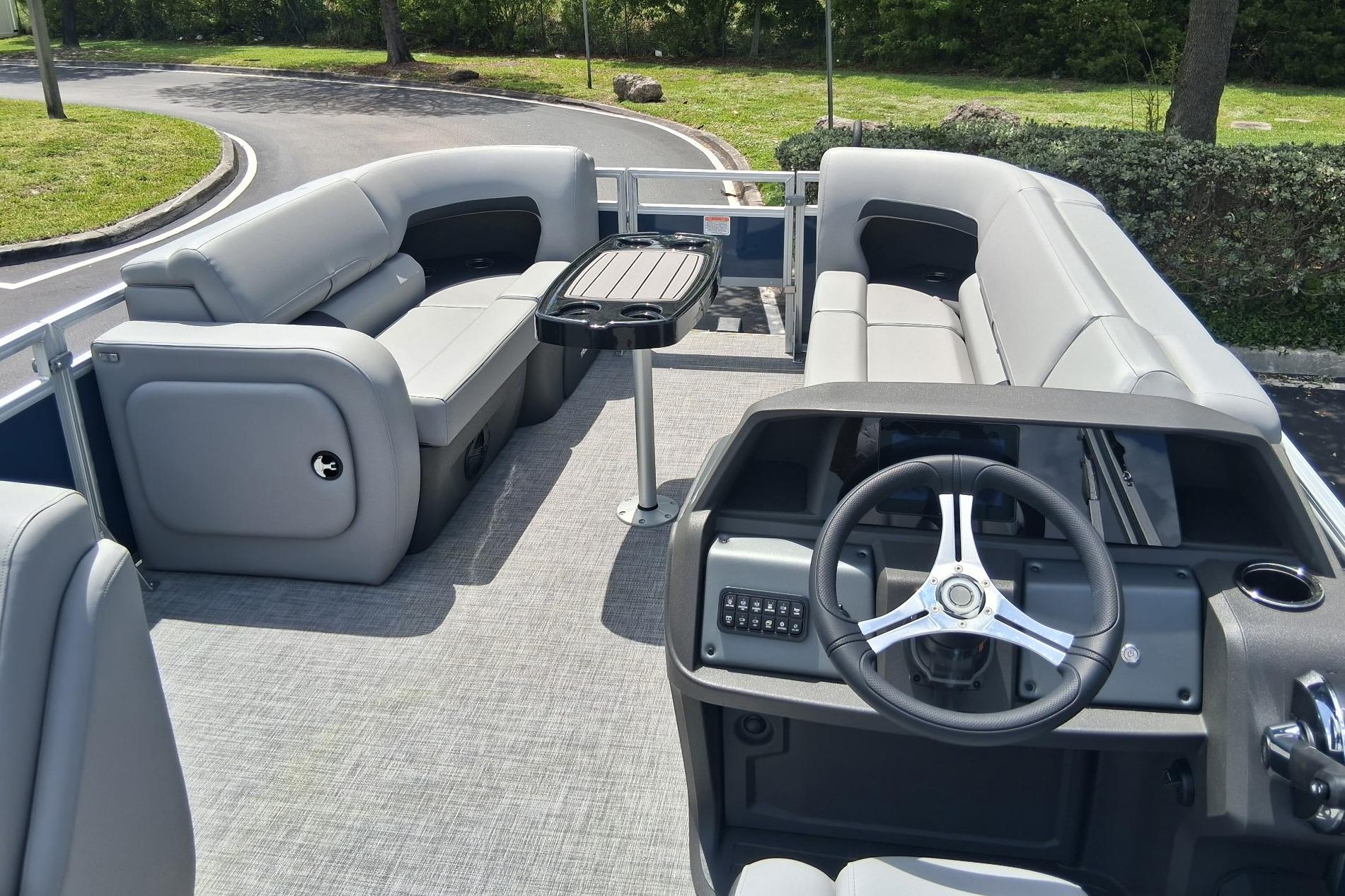 2026 Sun Tracker SportFish 22 DLX pontoon boat interior with seating and steering console.