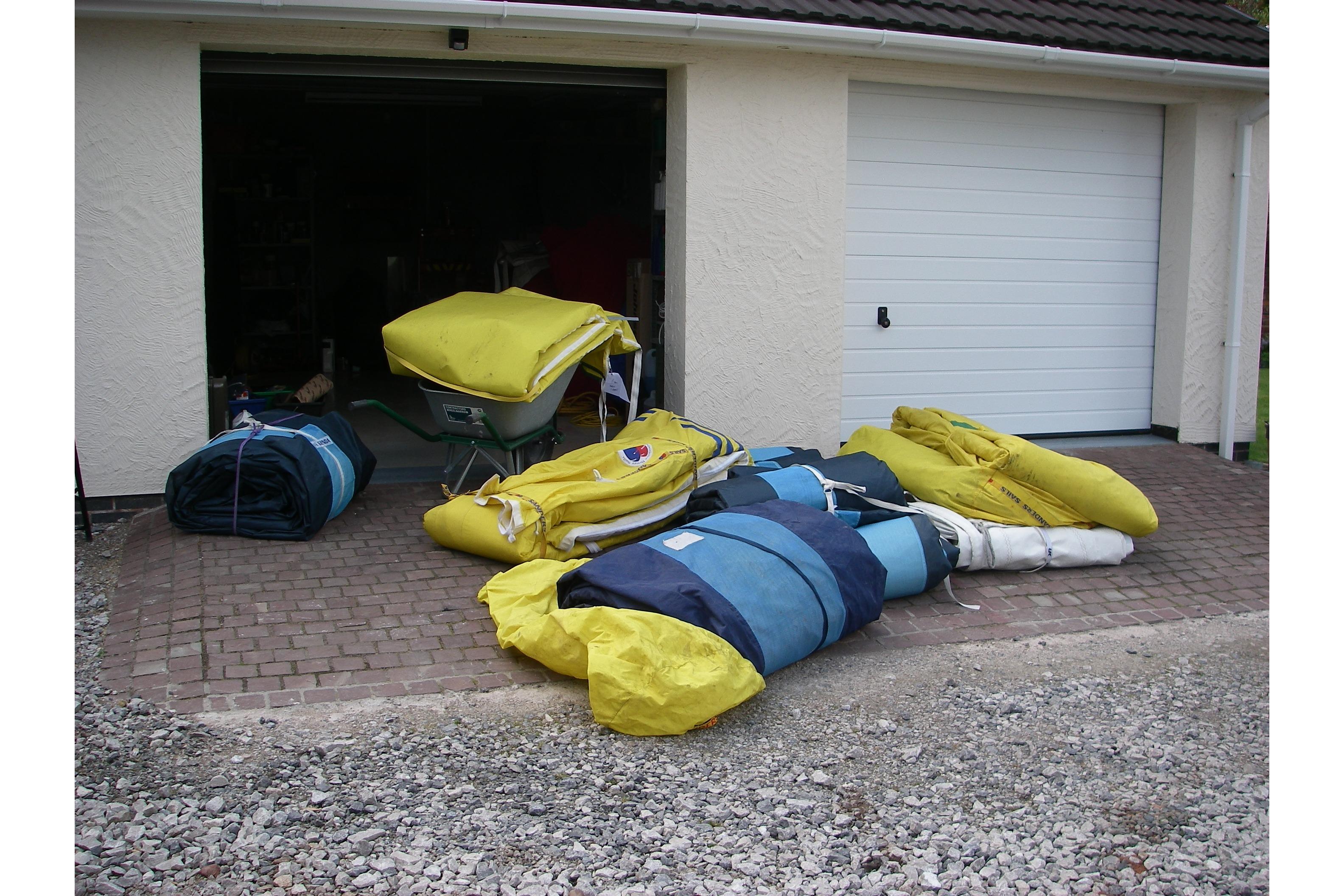 Sails and equipment from a 1980 Nautor Swan 411 yacht outside a garage.