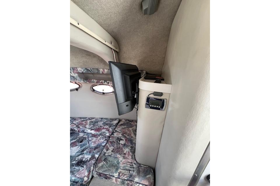 1997 Crownline 250 CR cabin interior with TV and patterned upholstery.