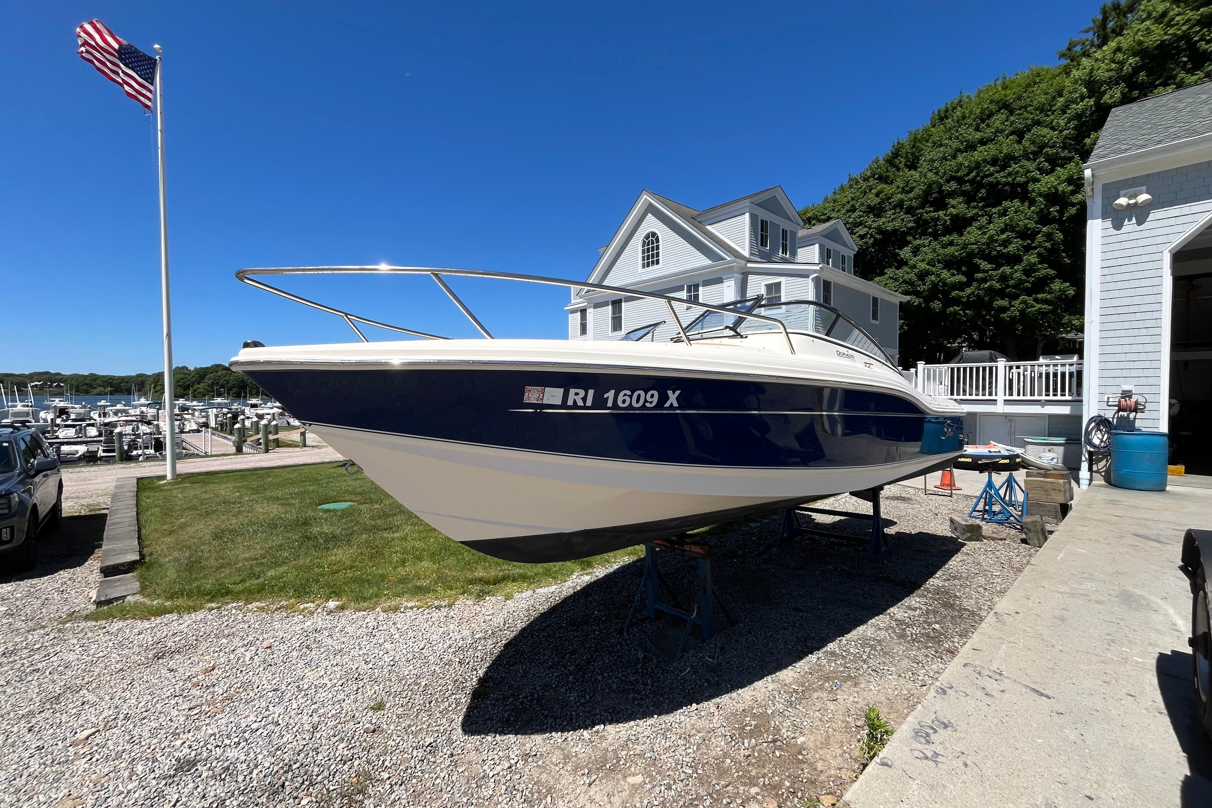 2017 Scout 210 Dorado boat on trailer near marina and house.