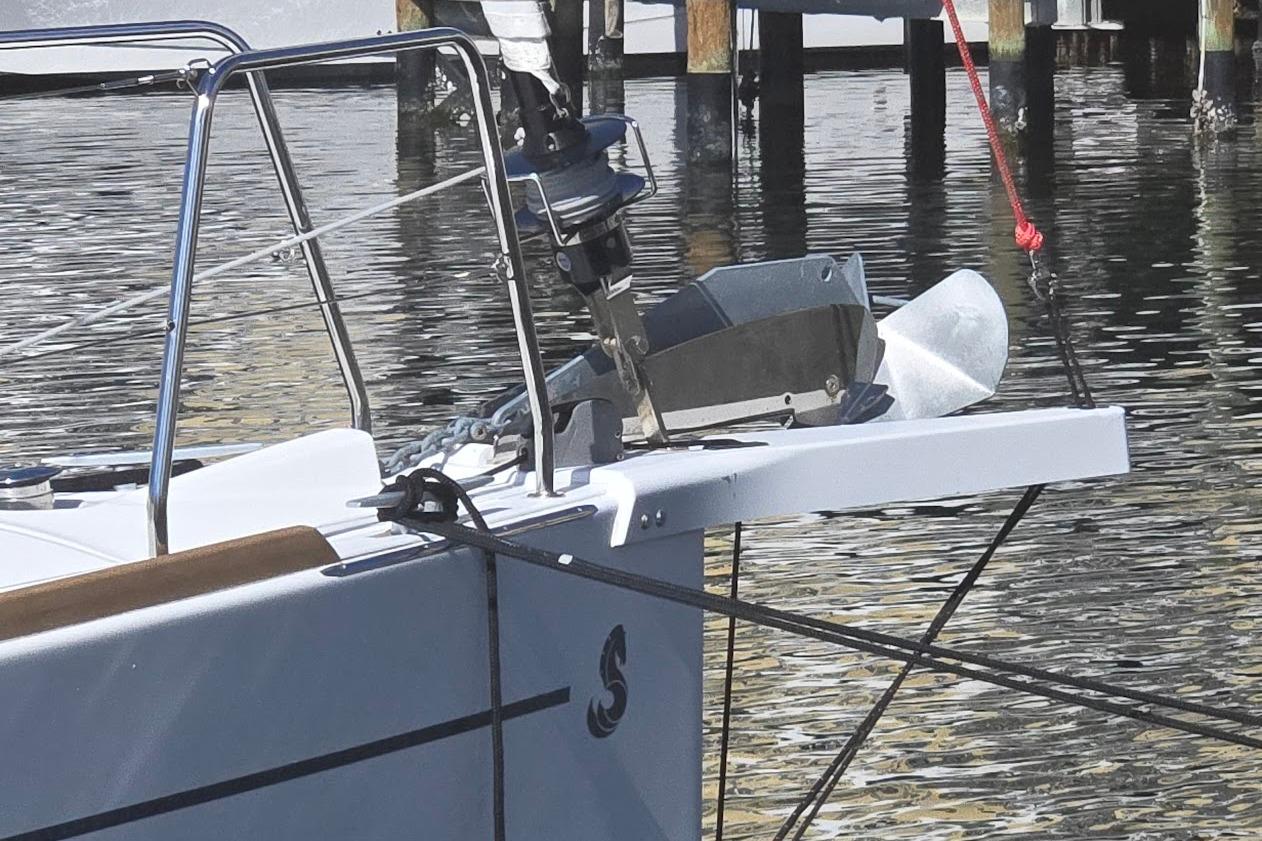 2023 Beneteau Oceanis 38.1 yacht bow with anchor, docked in calm waters.