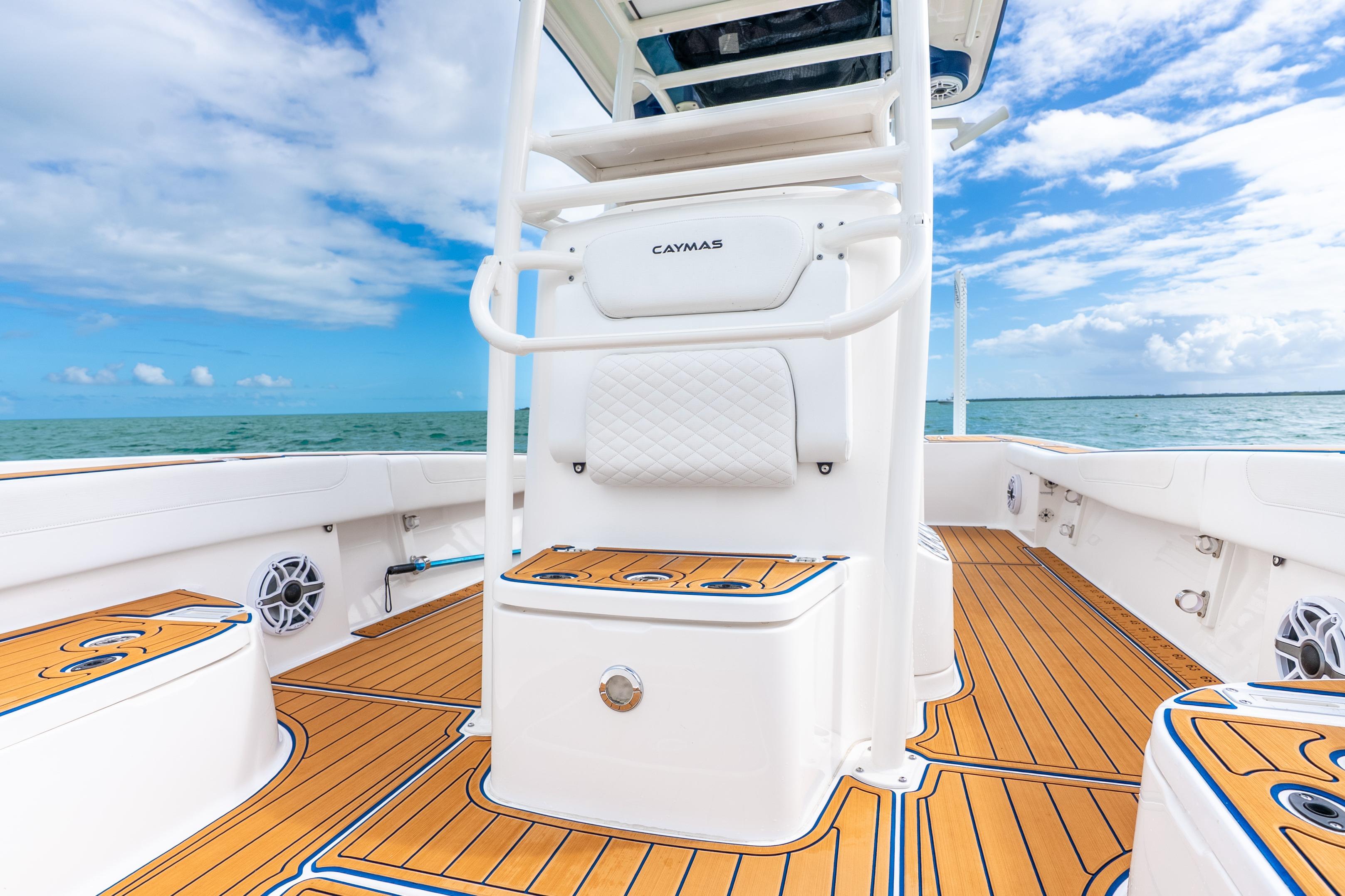 2024 Caymas 281 HB boat interior with teak flooring, ocean view, and clear sky.