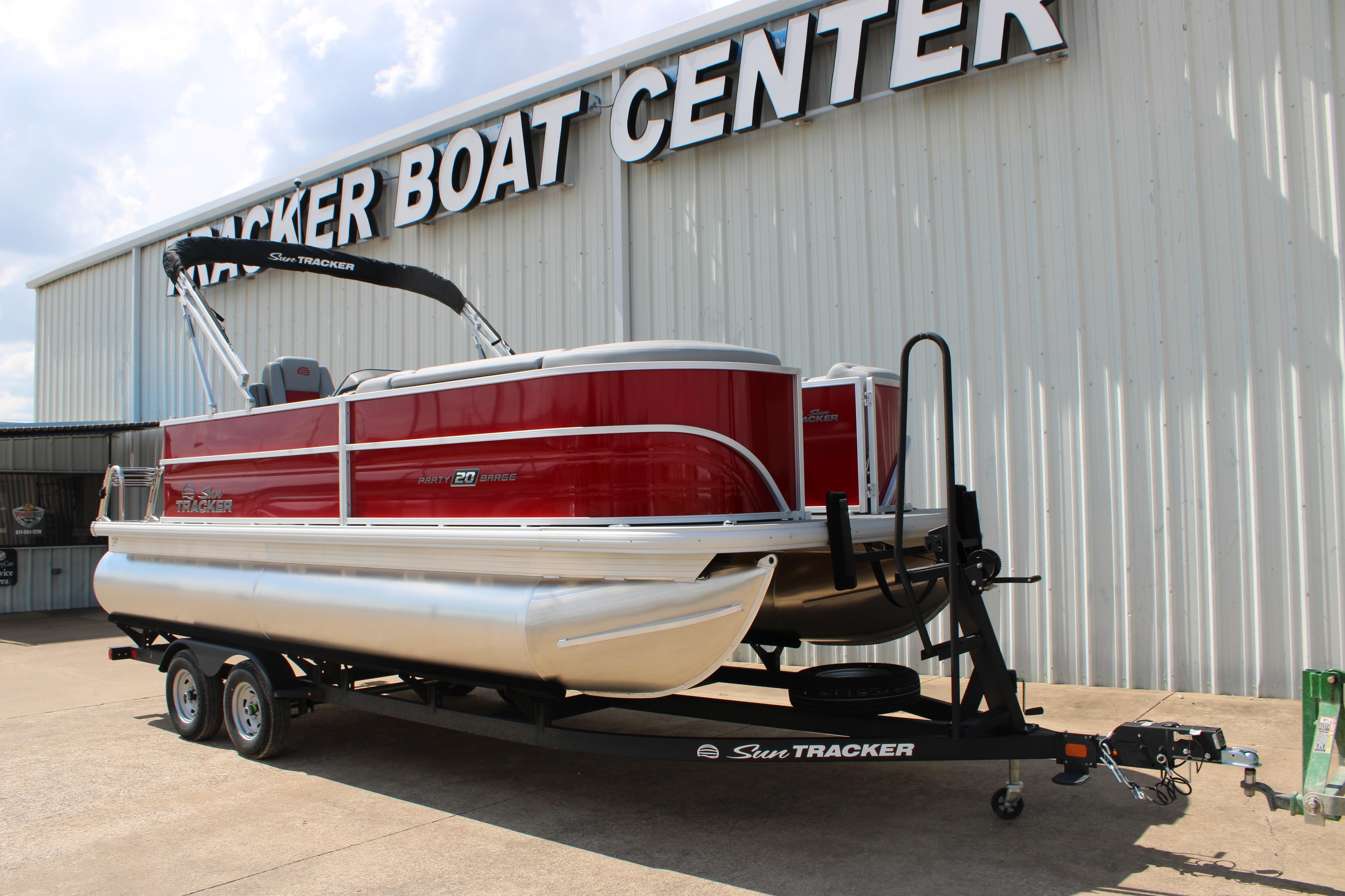 2026 Sun Tracker Party Barge 20 DLX pontoon boat on trailer at dealership.