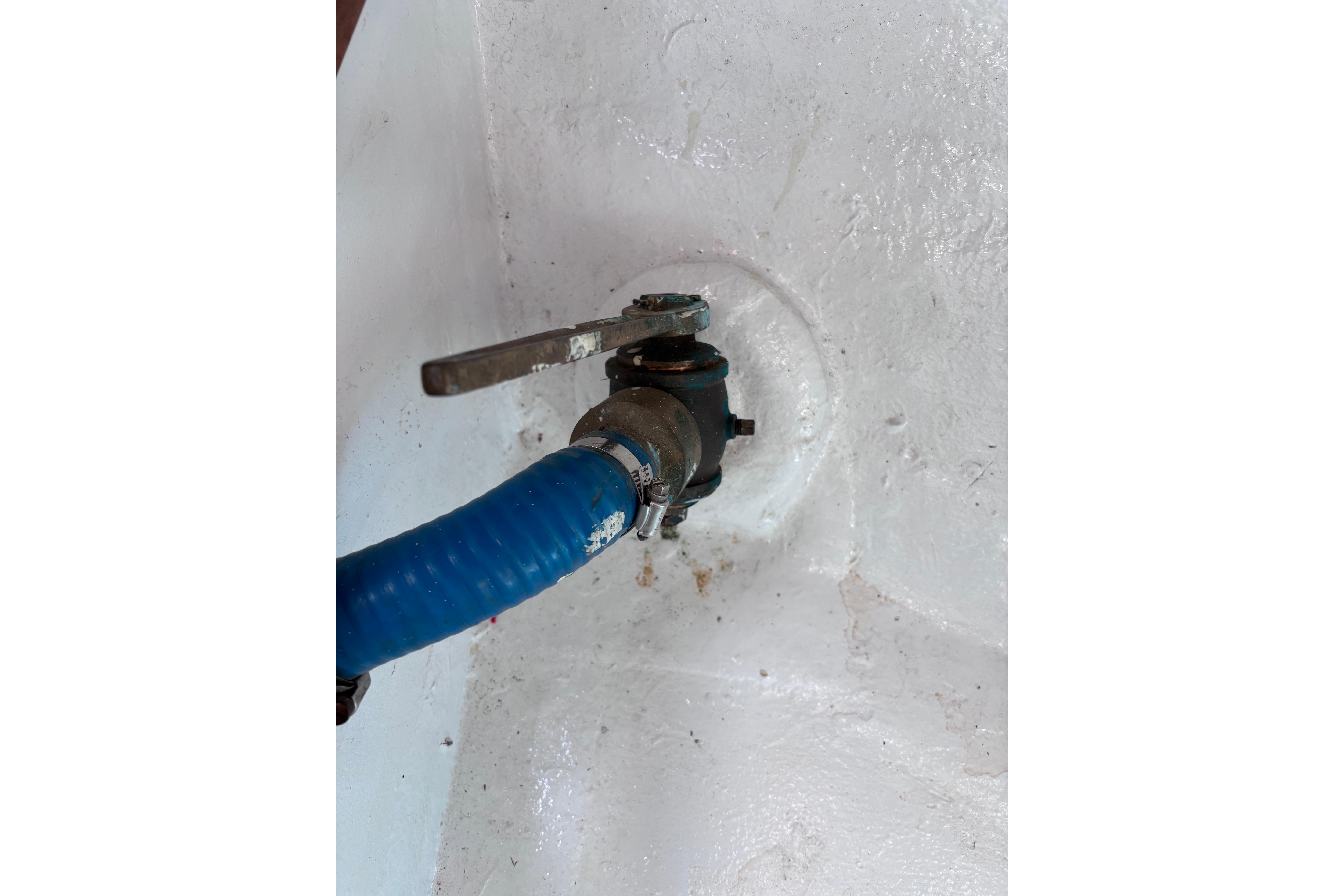 Blue hose connected to a metal valve inside a 1978 Swift 33 model.