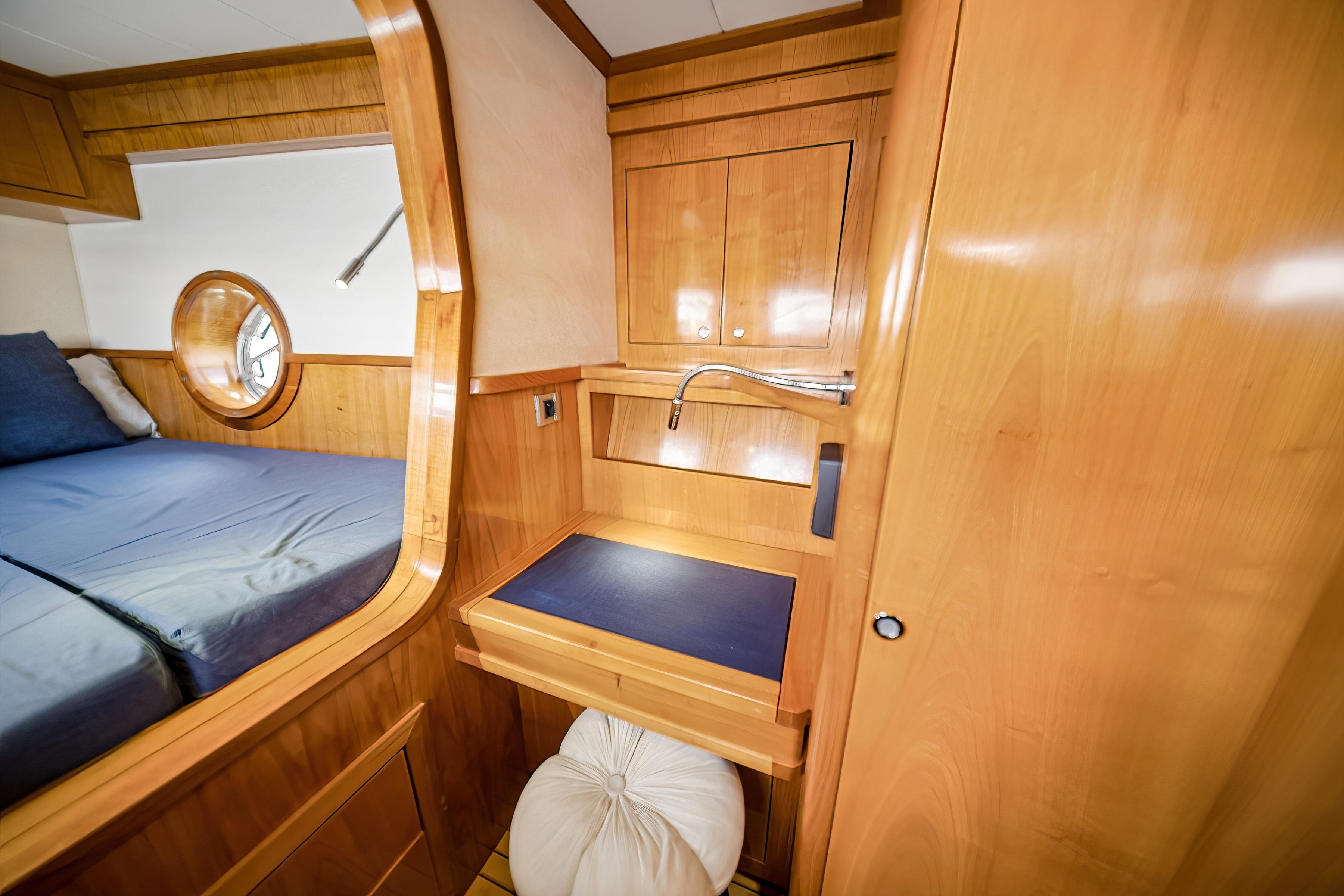Luxurious 2009 Catana 65 yacht cabin with wooden interior and cozy bed.