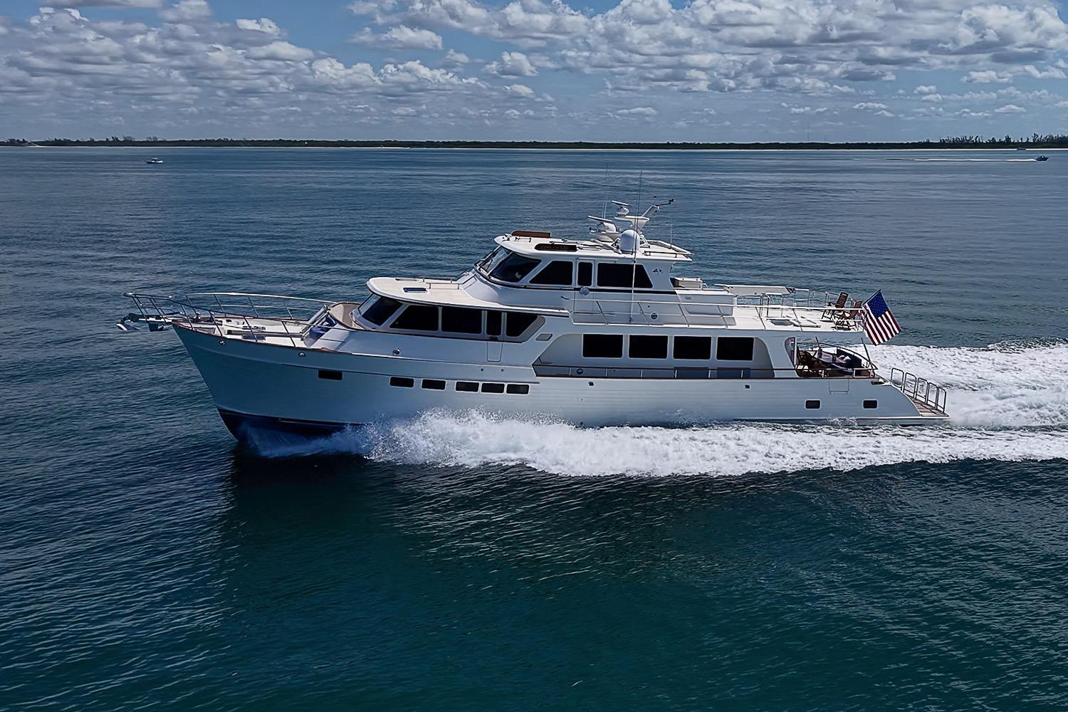 Luxury 2014 Marlow 80 Explorer yacht cruising on open water under a partly cloudy sky.