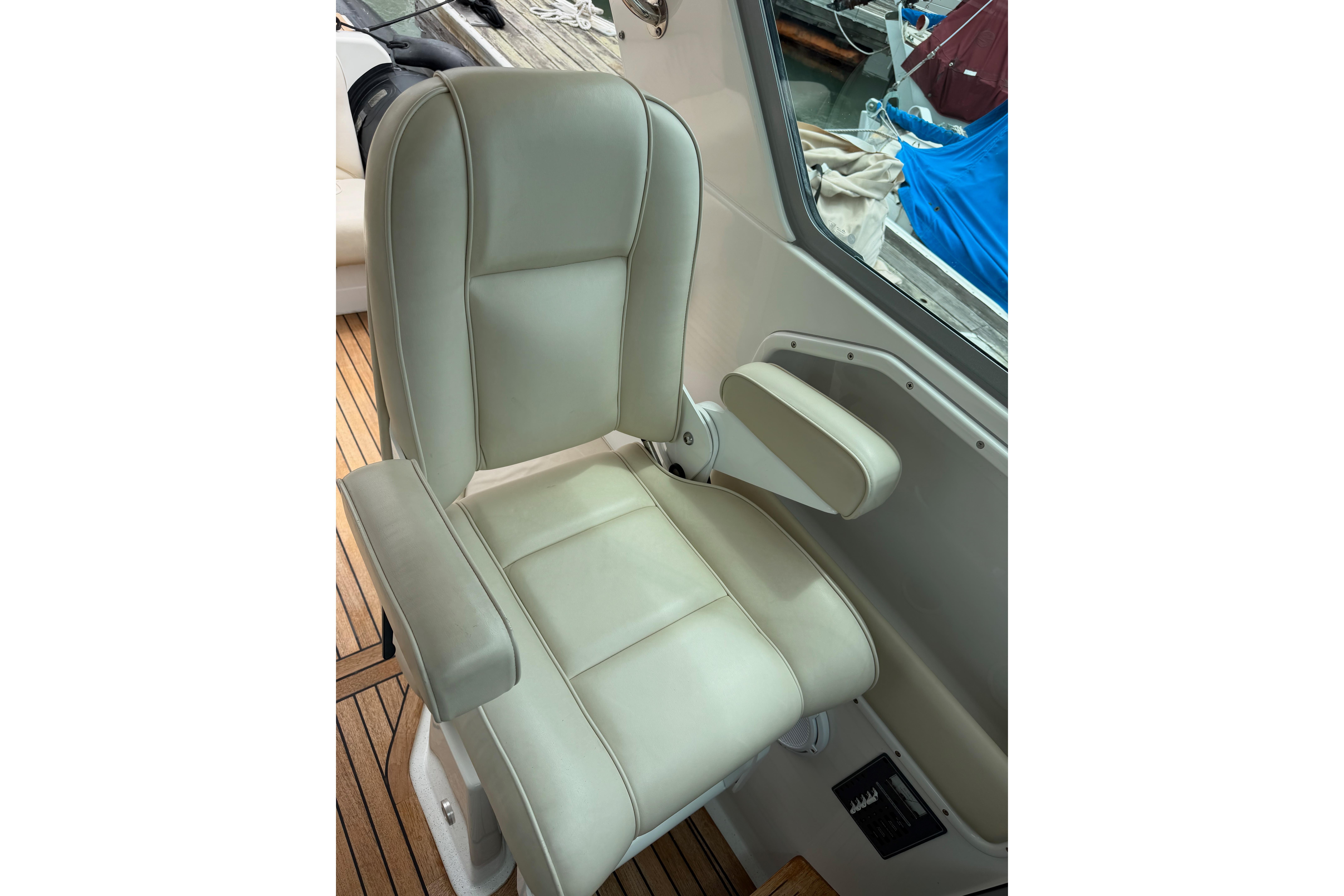 Captain's chair on 2016 Protector Targa 30 boat, featuring beige upholstery and armrests.