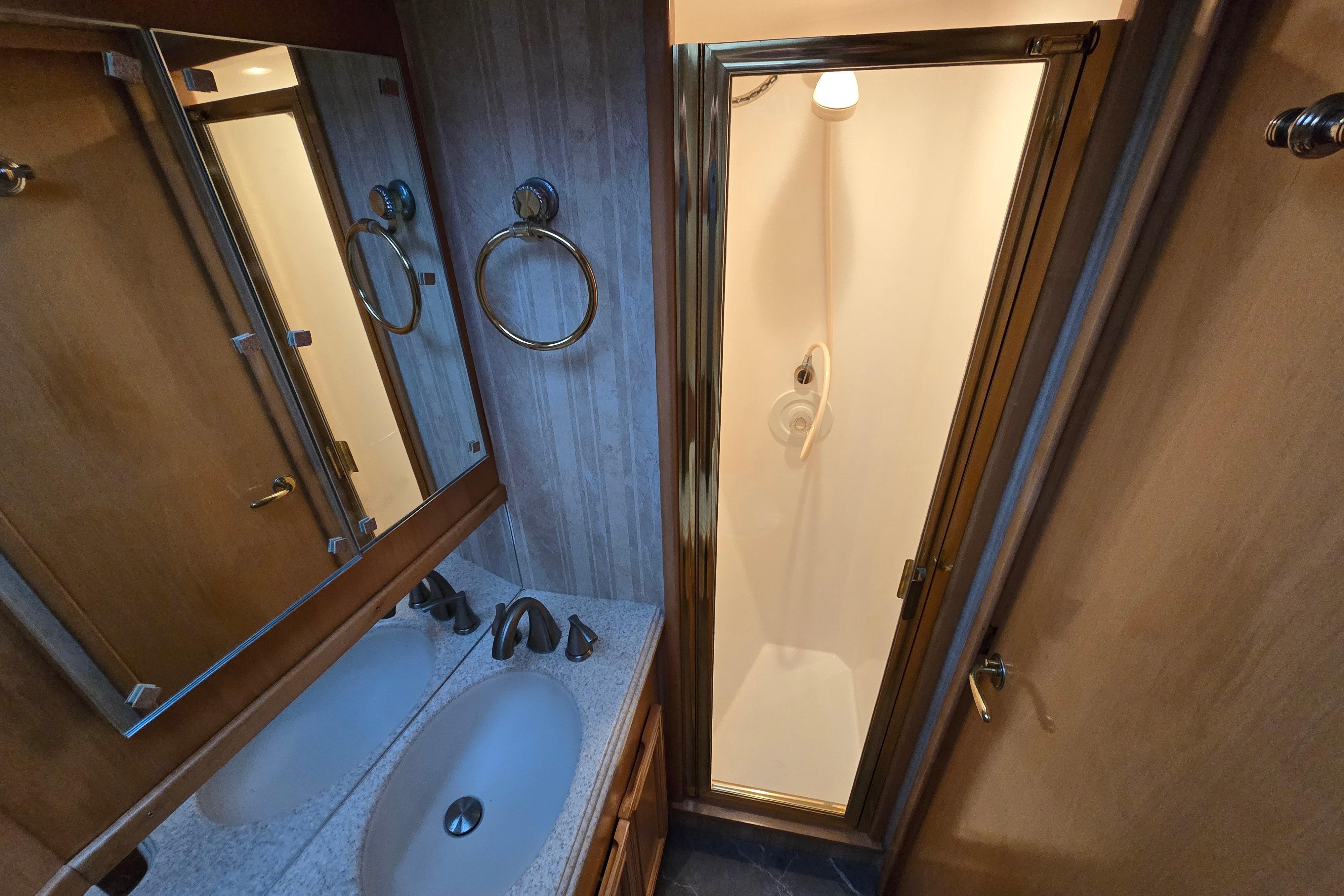 Bathroom interior of 2001 Cavileer 53 Convertible yacht with shower and dual sinks.