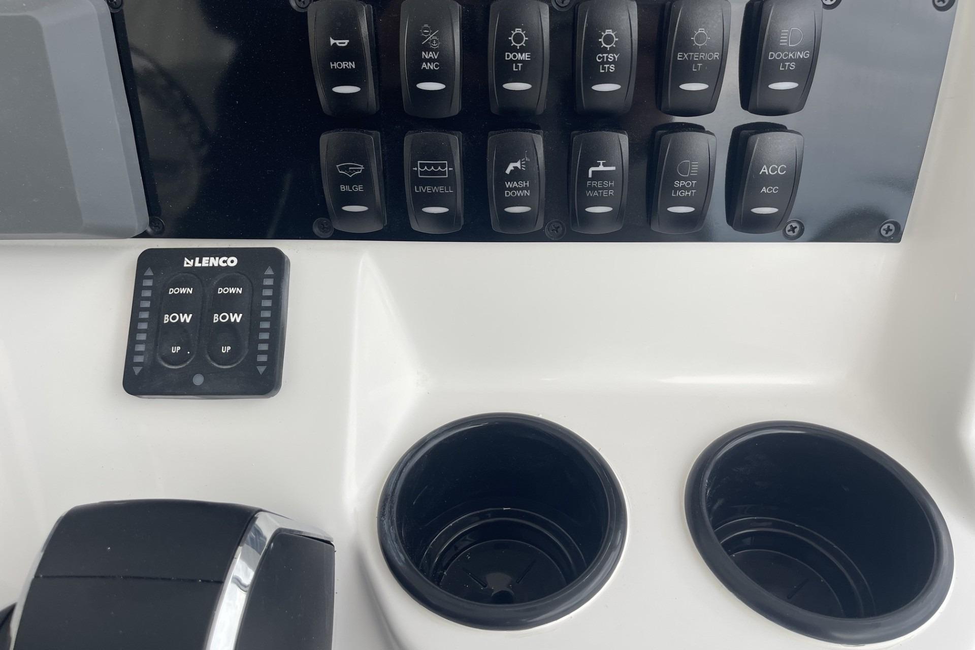 Control panel of 2026 Hurricane Center Console 24 OB boat with switches and cup holders.