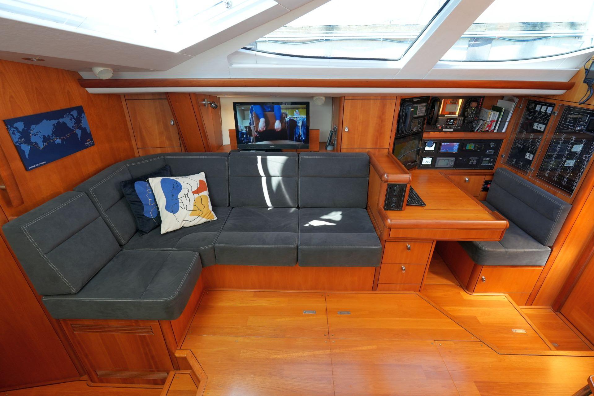 Luxurious interior of 2011 Oyster 575 yacht with plush seating and navigation station.