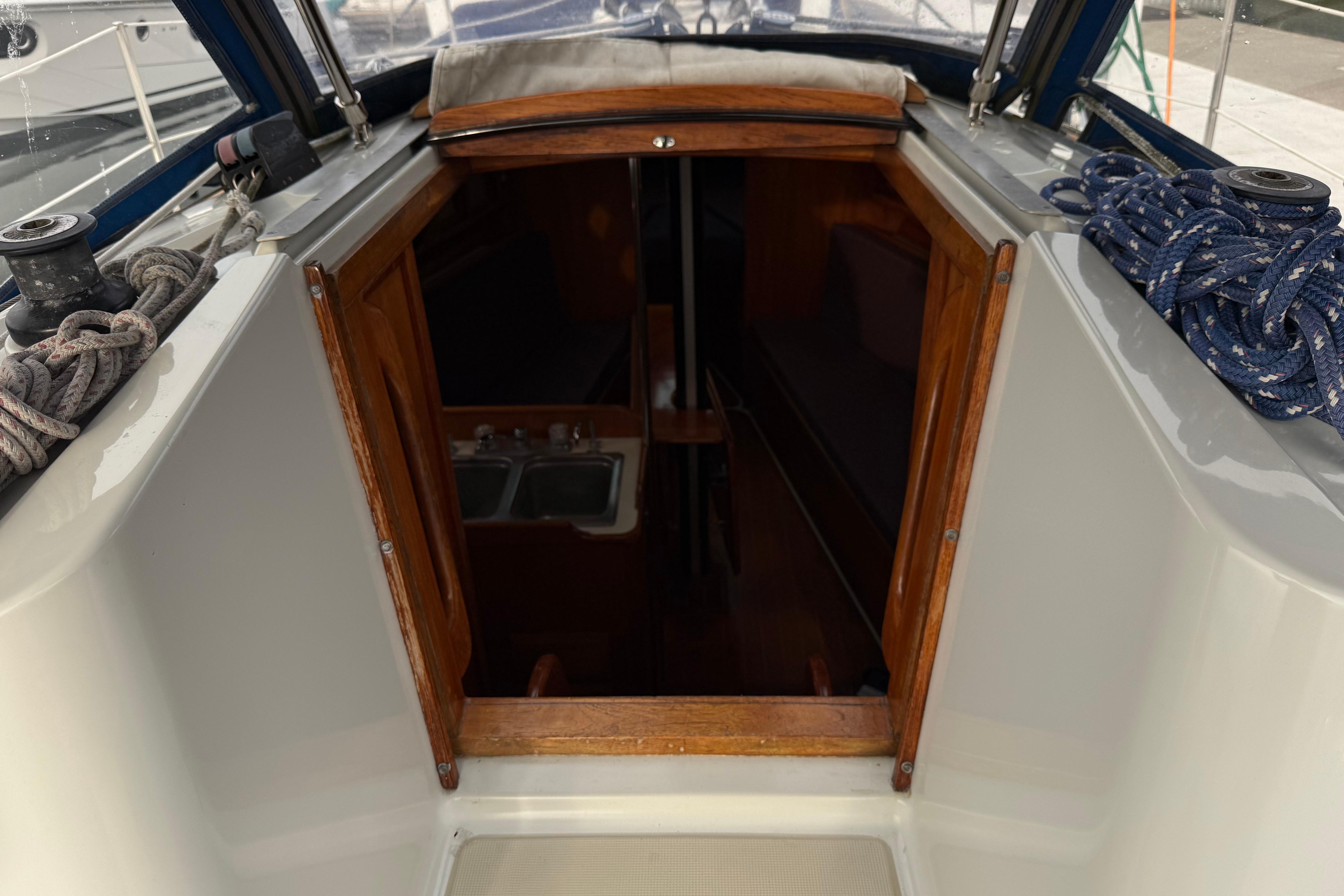 Cockpit view of 1988 Ericson 32-200 sailboat, showing cabin entrance and ropes.