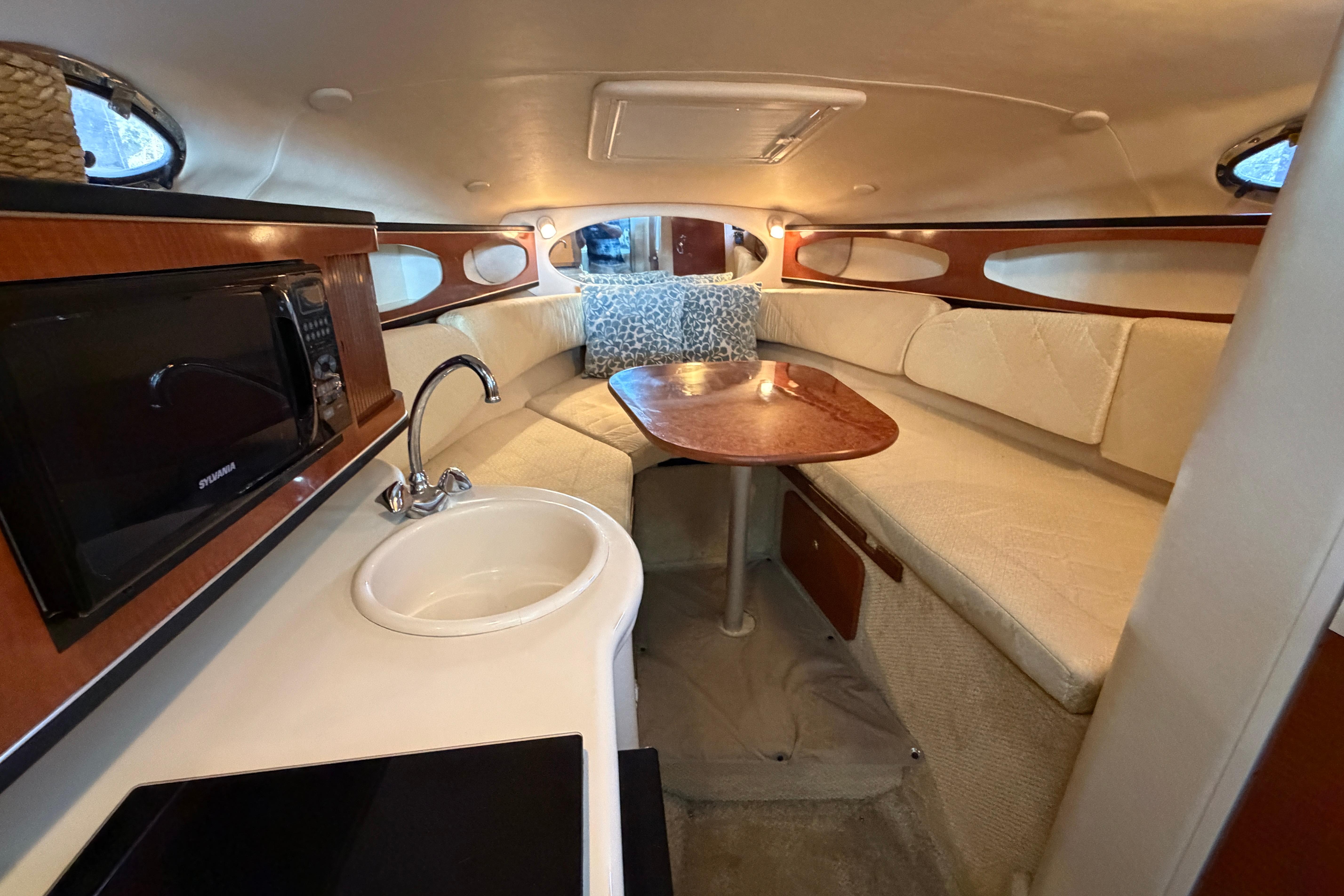 2004 Sea Ray Sundancer 260 cabin interior with kitchenette and seating area.