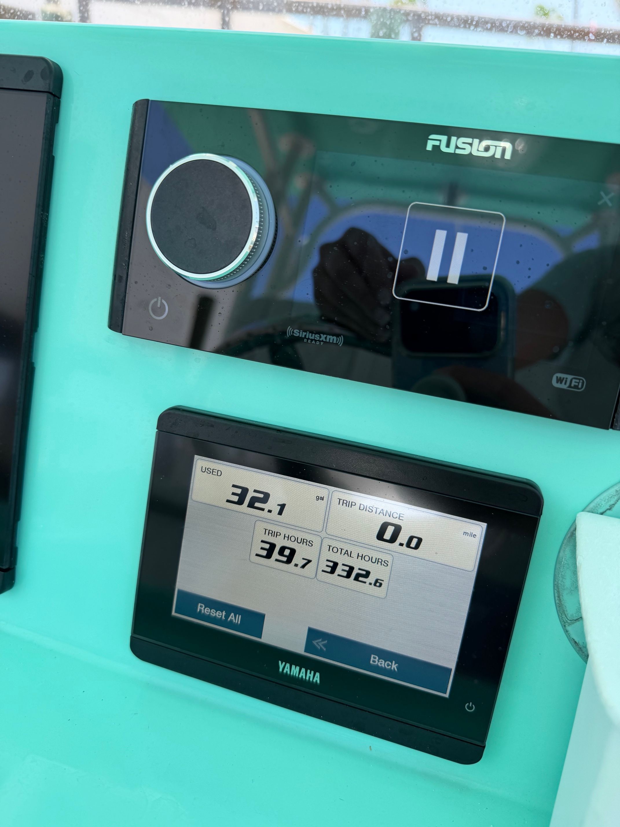 Close-up of a boat dashboard featuring a Fusion audio system and a Yamaha display.