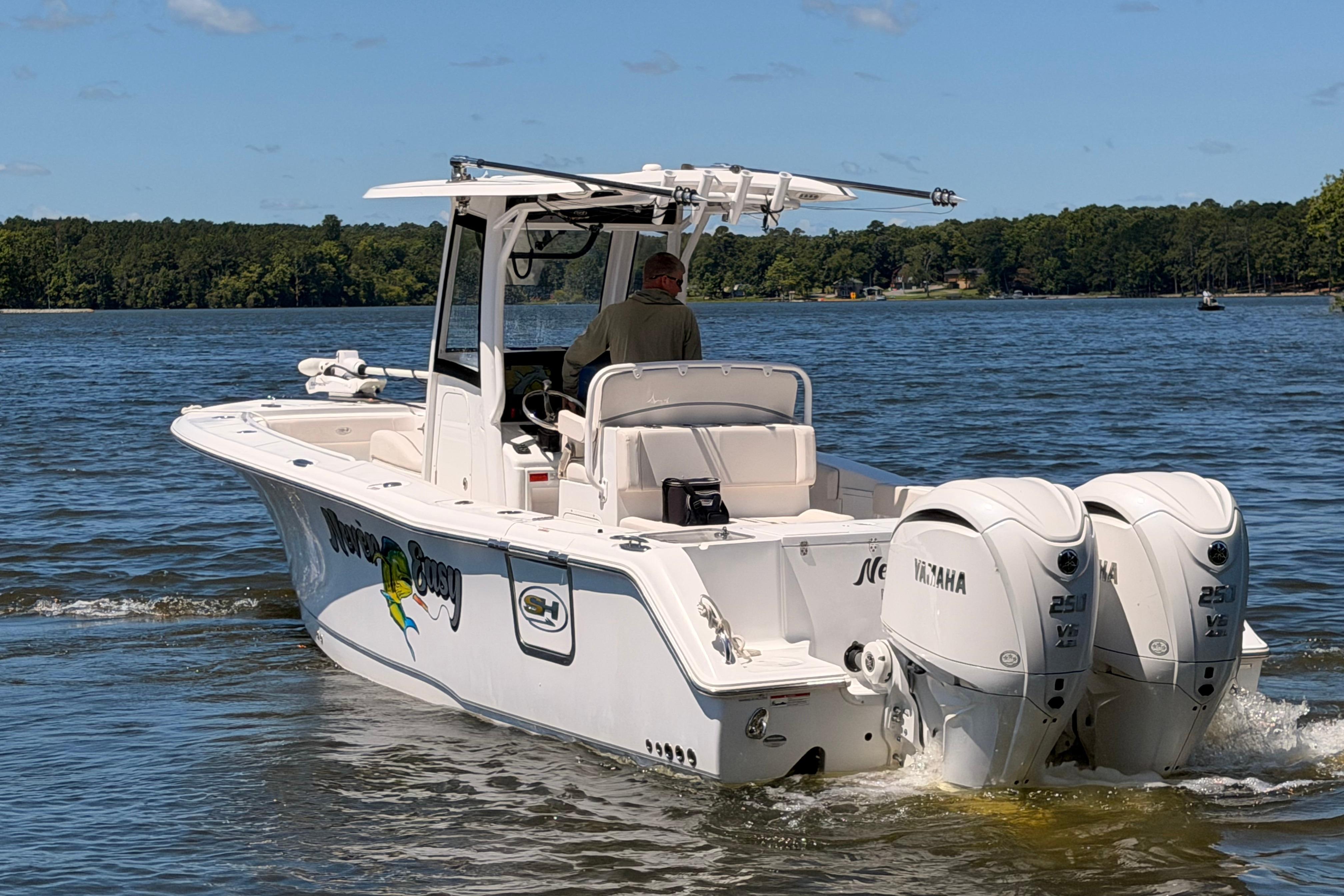 2024 Sea Hunt Gamefish 27 Coffin Box boat cruising on a lake with twin Yamaha engines.