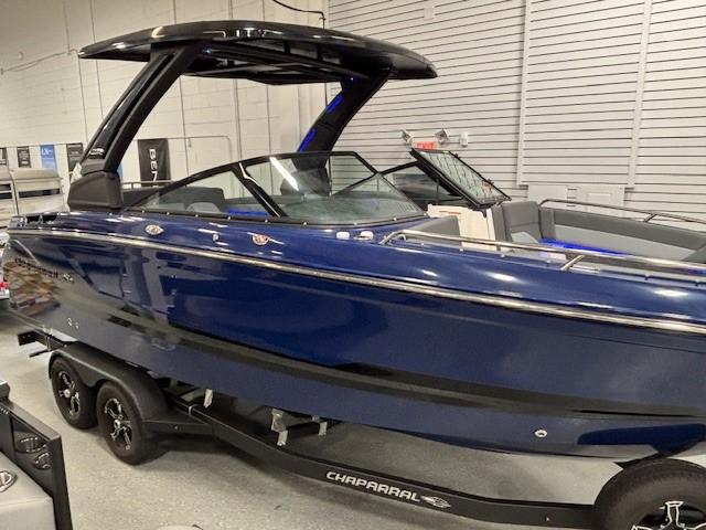 2026 Chaparral SSX 6 boat in showroom, sleek blue design on trailer.