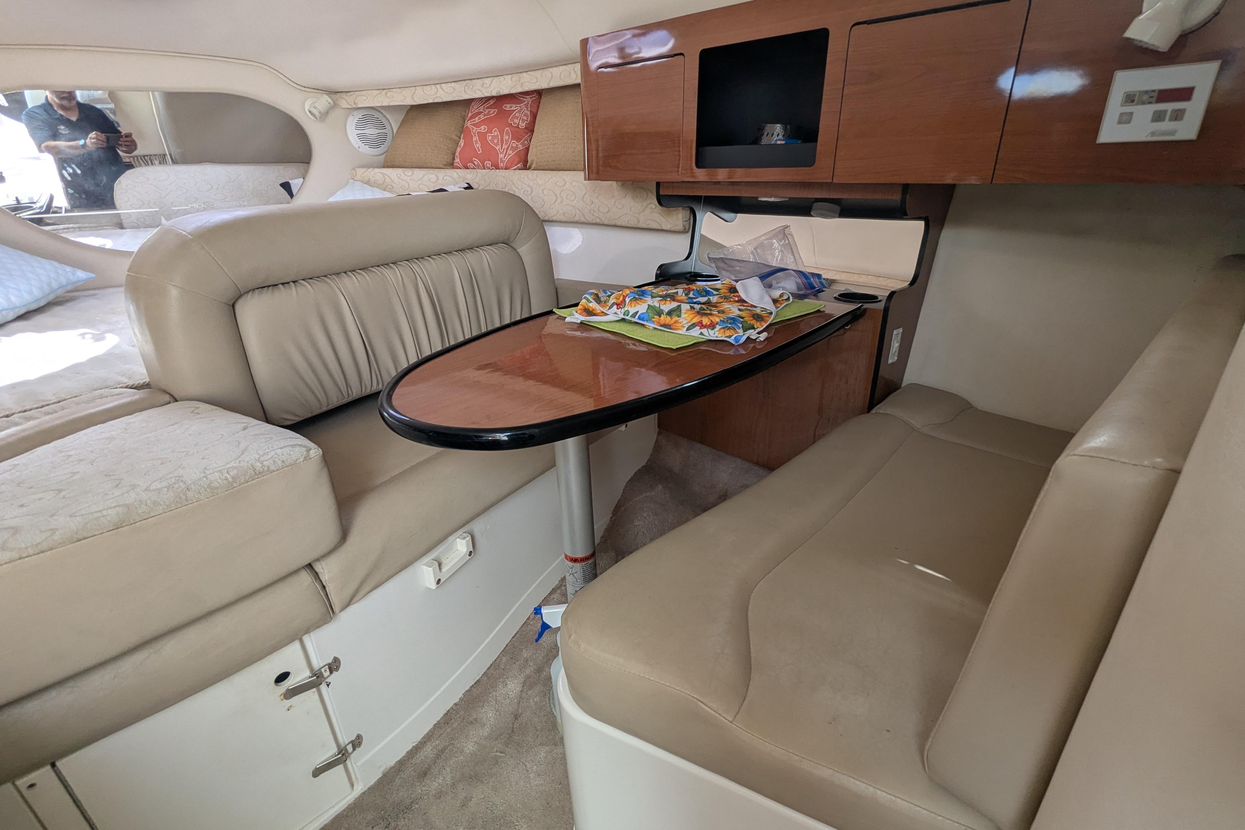 Interior of a 2003 Monterey 282 Cruiser with beige seating and wooden cabinetry.