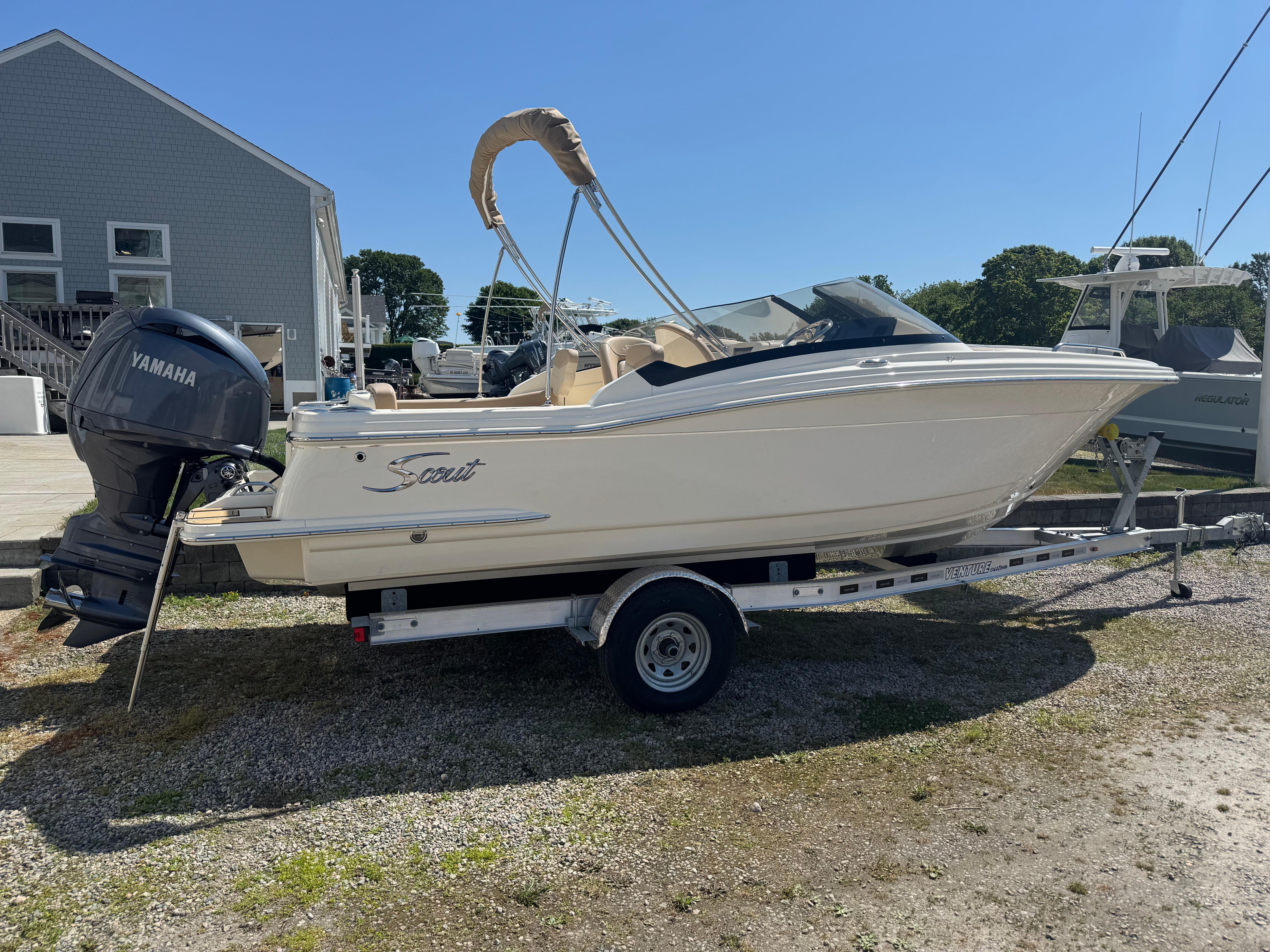 2025 Scout 215 Dorado boat on trailer with Yamaha outboard motor, parked outdoors.