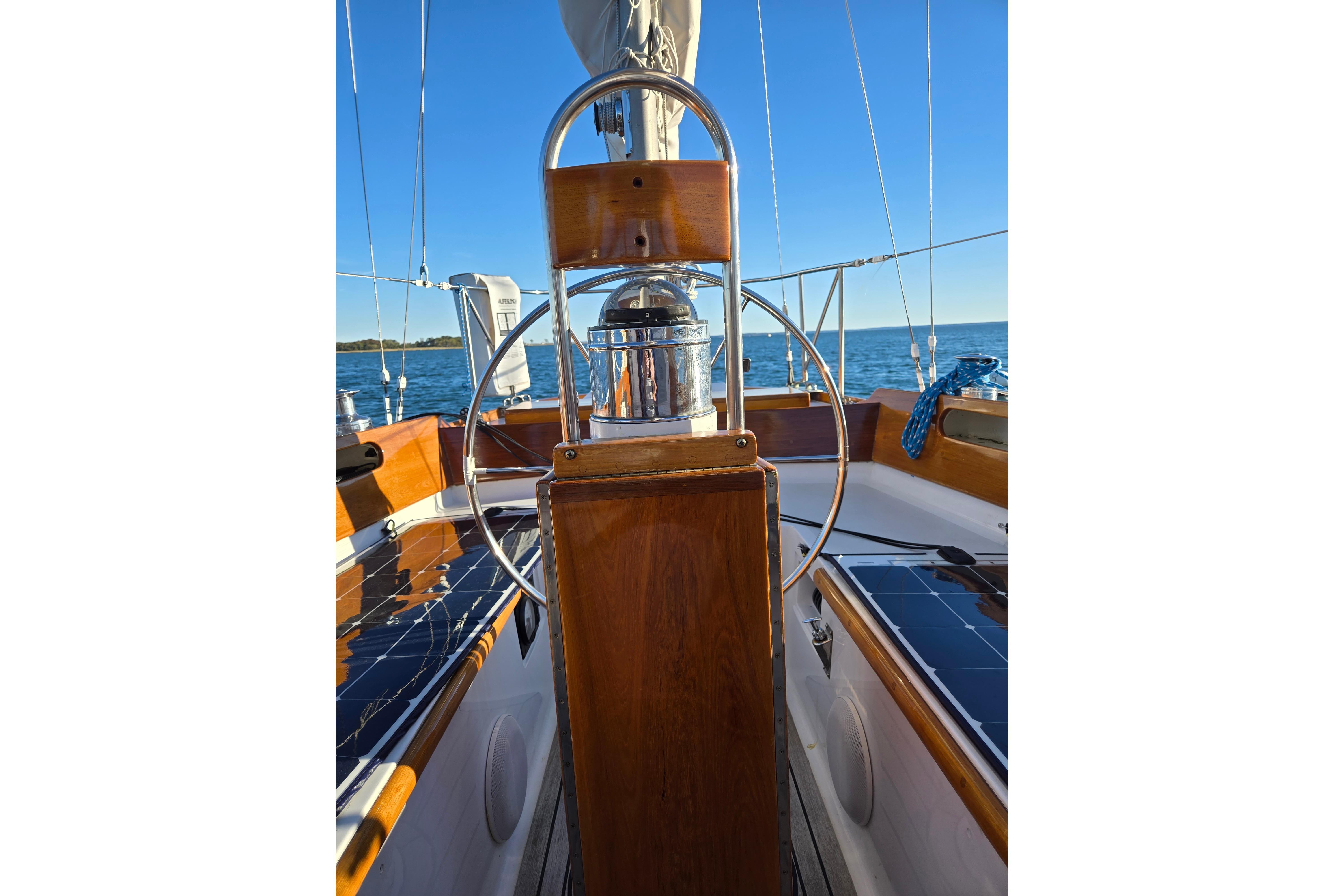 1970 Hinckley Bermuda 40 sailboat cockpit with wooden helm and ocean view.