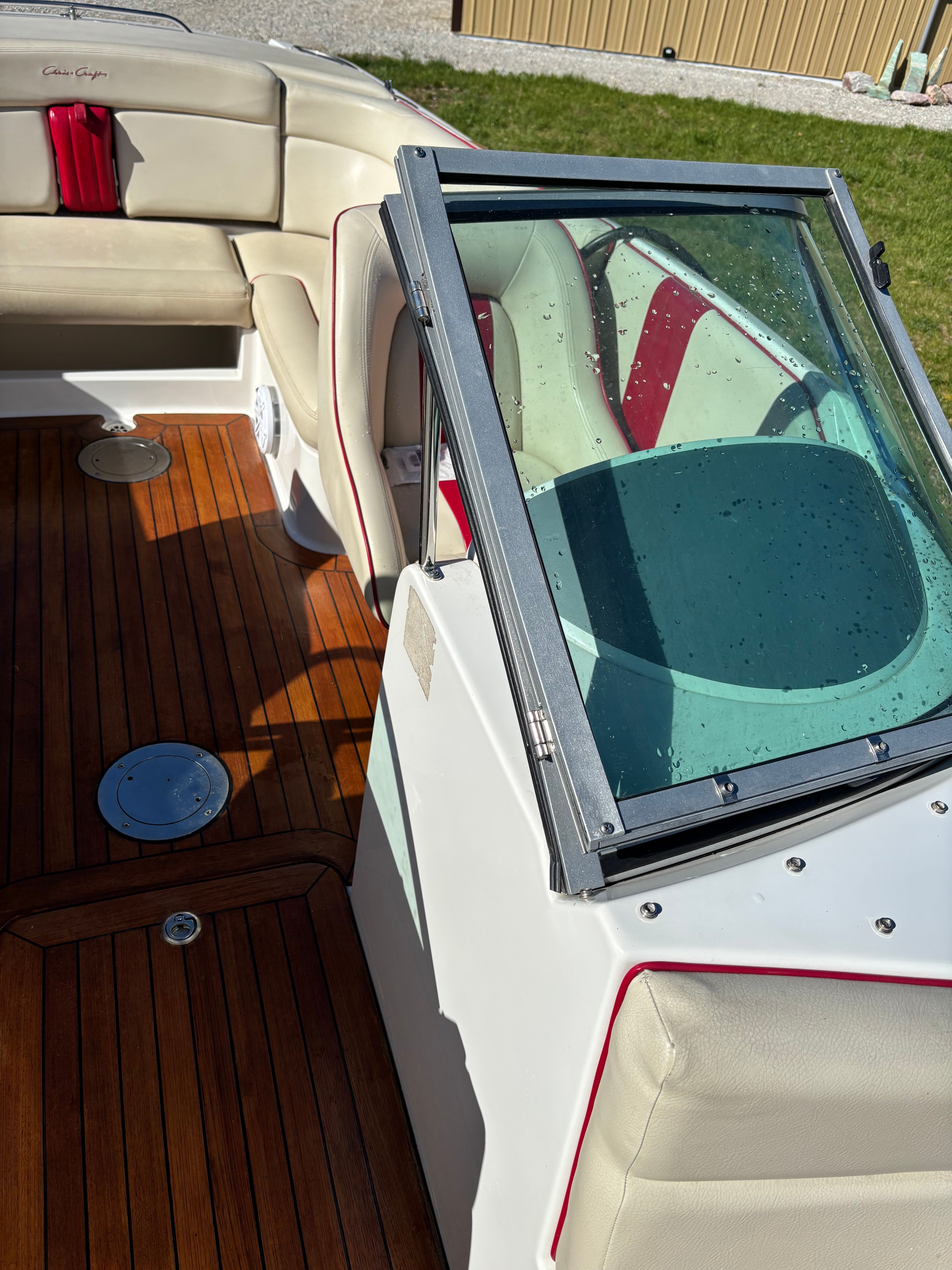 Interior of a Chris-Craft Launch 22 boat with wooden flooring and beige seats.