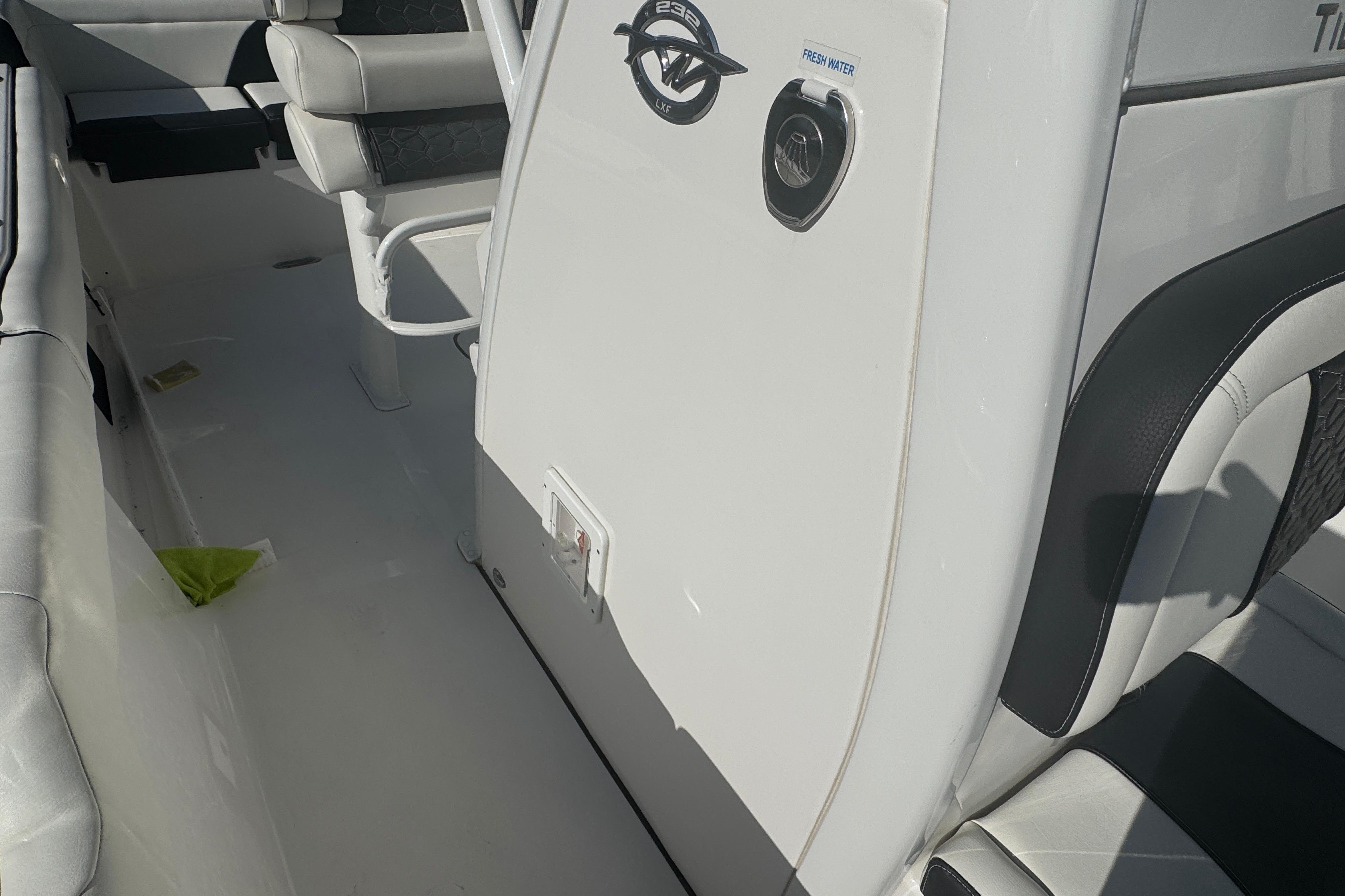 Interior view of a 2025 Tidewater 232 LXF boat, featuring seating and control panel.