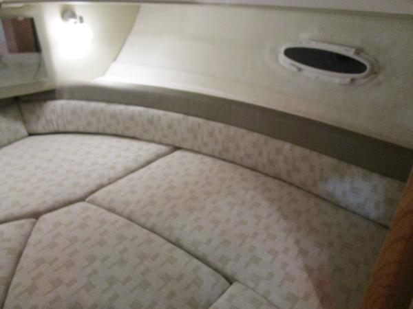 2025 Cutwater C-248 Coupe interior cabin with cushioned seating and porthole window.