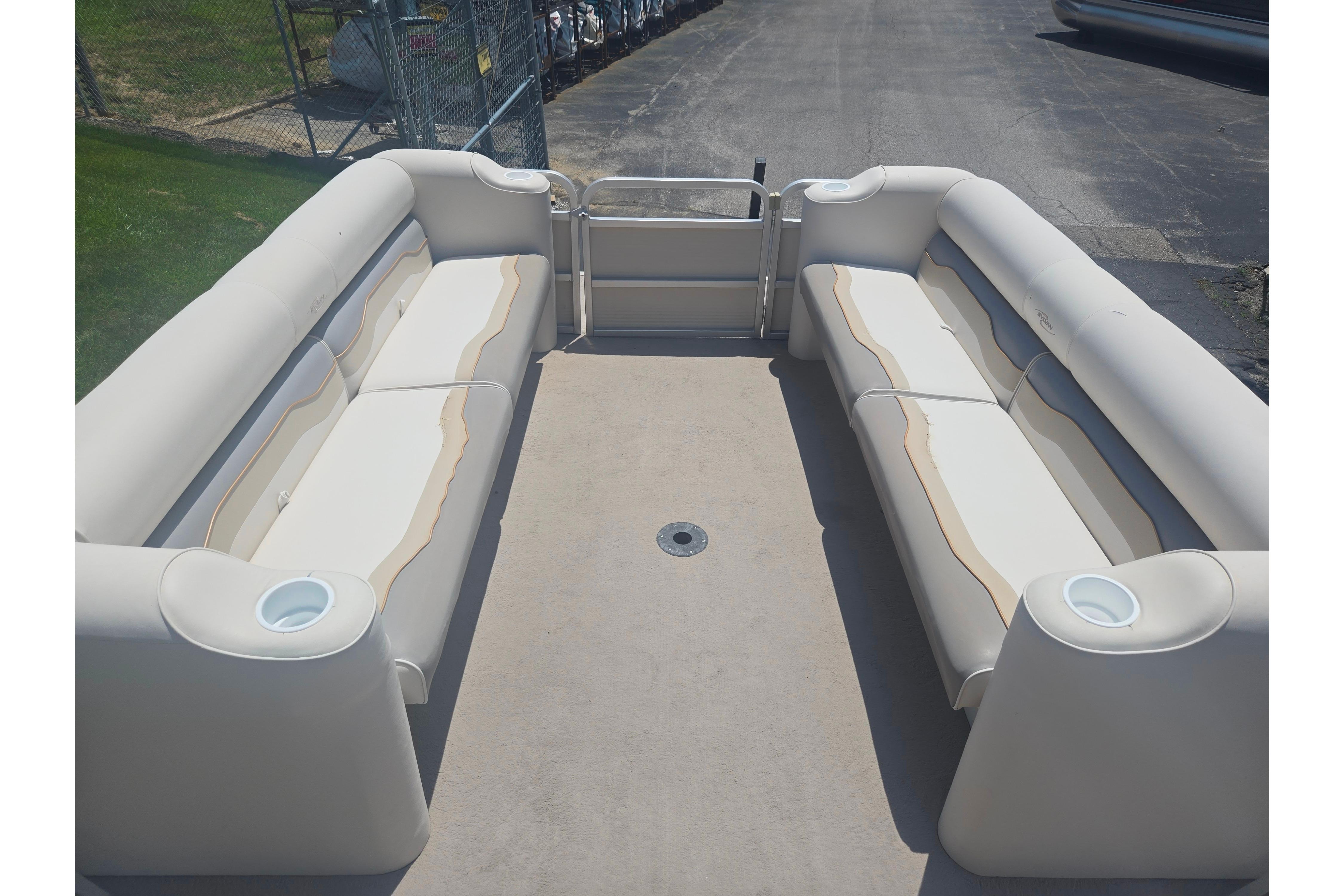 2000 Sylvan 824 Elite Cruise pontoon boat interior with beige seating and cup holders.