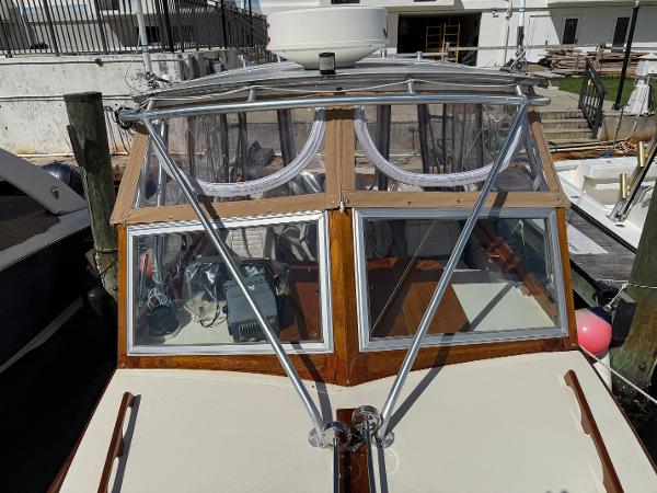 1978 Dyer 29 Trunk Cabin boat with glass windows and metal supports at dock.