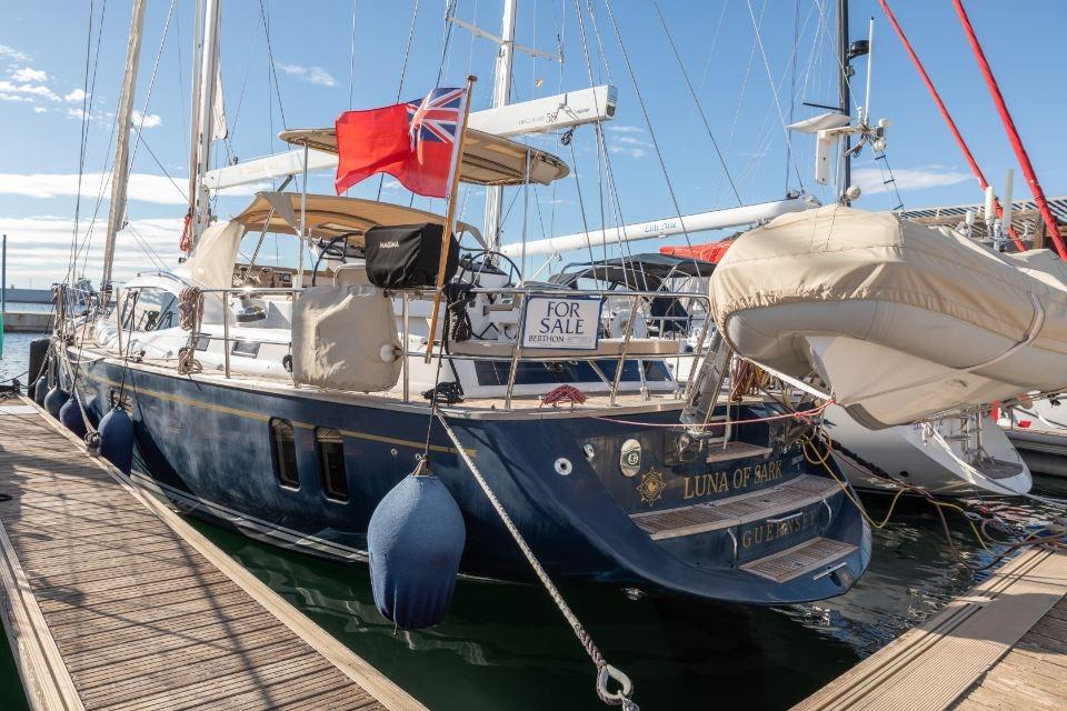 Sailing yacht Discovery 58, 2015 model, docked and for sale, with red flag.