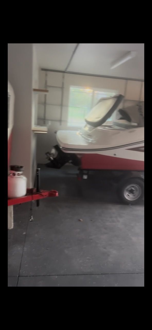 A 2016 Sea Ray SPX 190 Outboard is parked in a garage on a trailer.