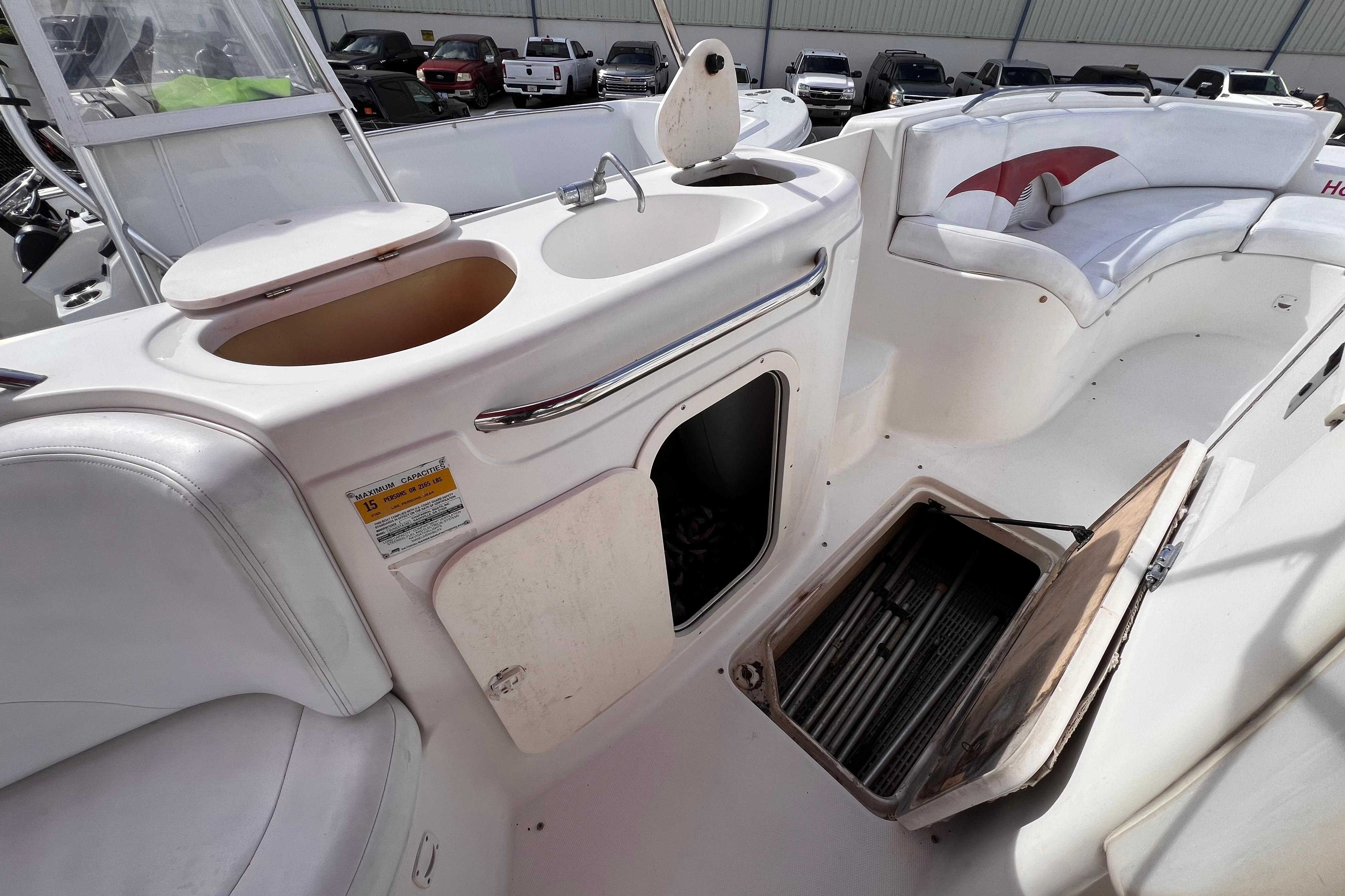 2002 Chaparral 232 Sunesta boat interior with sink, storage, and seating area.