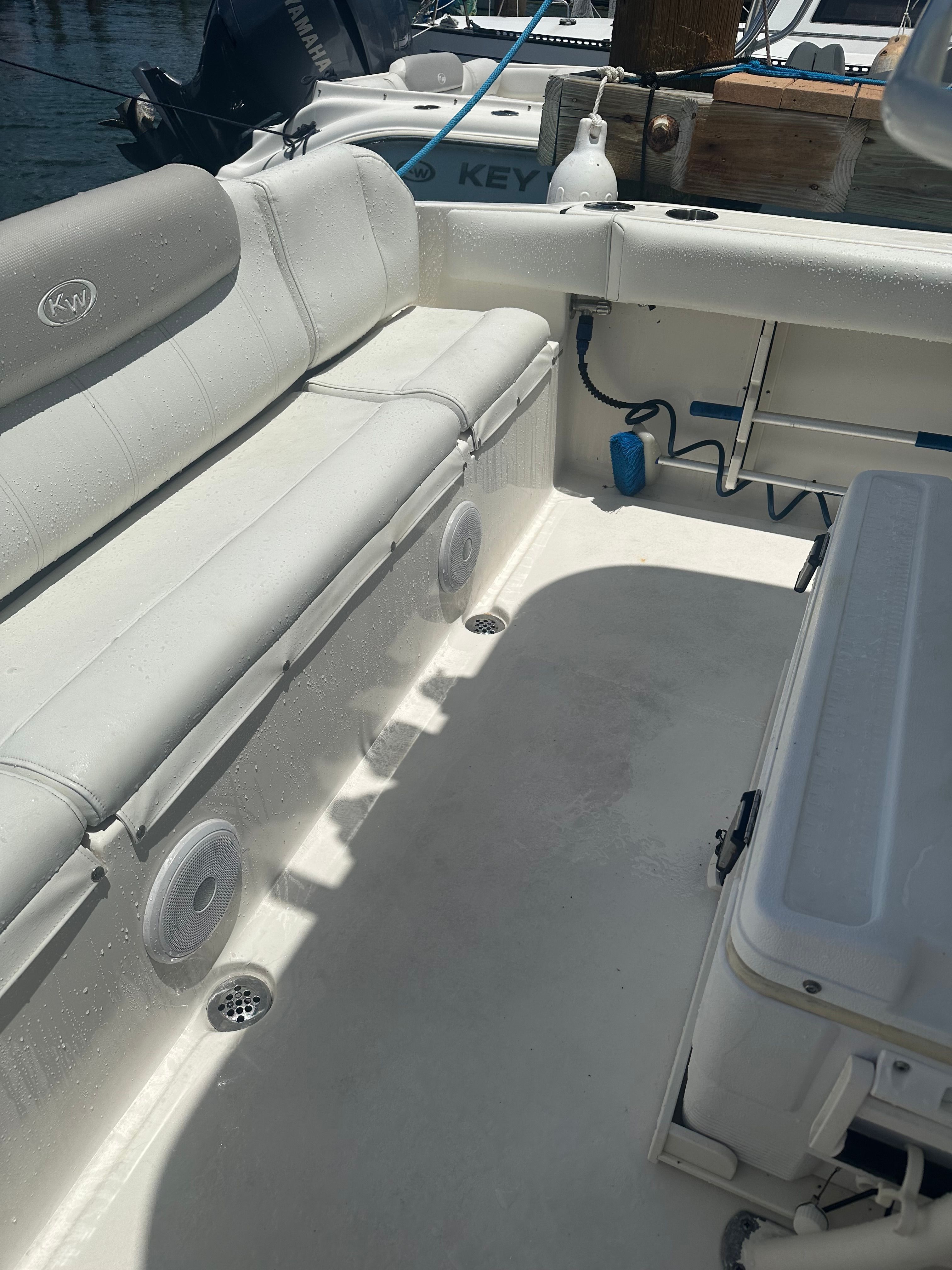 The image shows the interior of a Key West 219 FS boat with white seating and a clean deck.