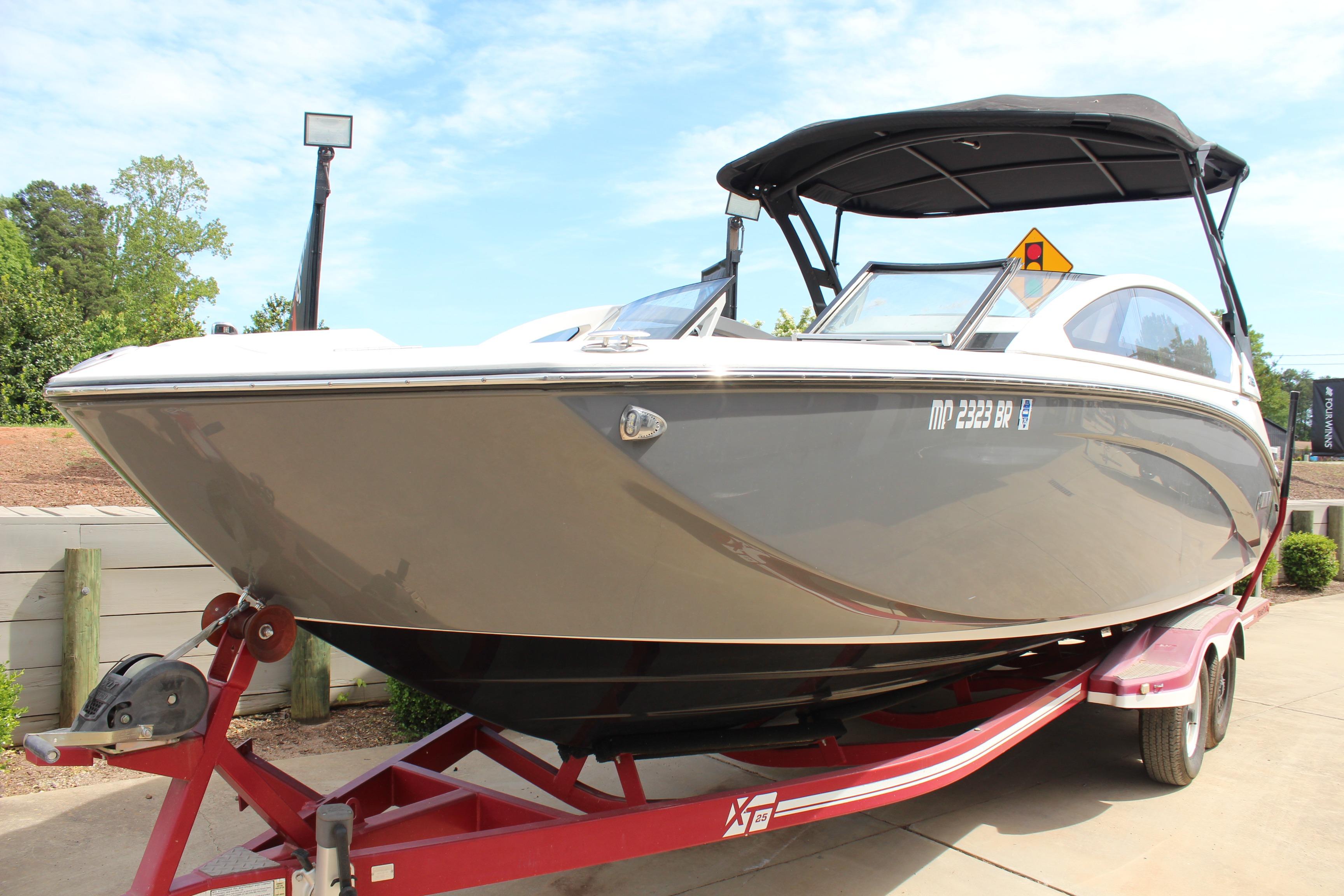 2020 Yamaha Boats 275SE on trailer, sleek design, black canopy, parked outdoors.