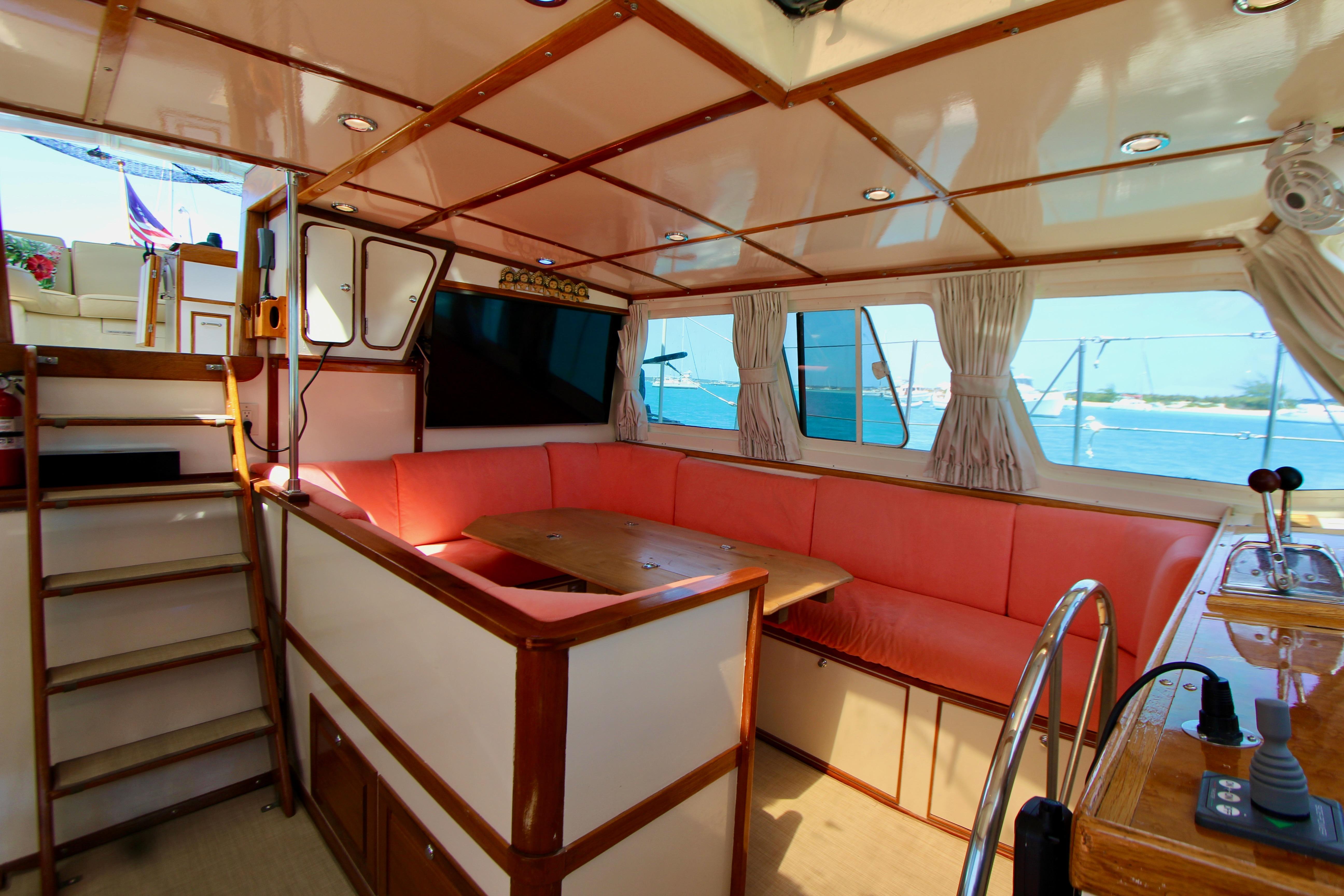 Interior of 1995 Benford Custom Pilothouse Cutter with cozy seating and nautical decor.