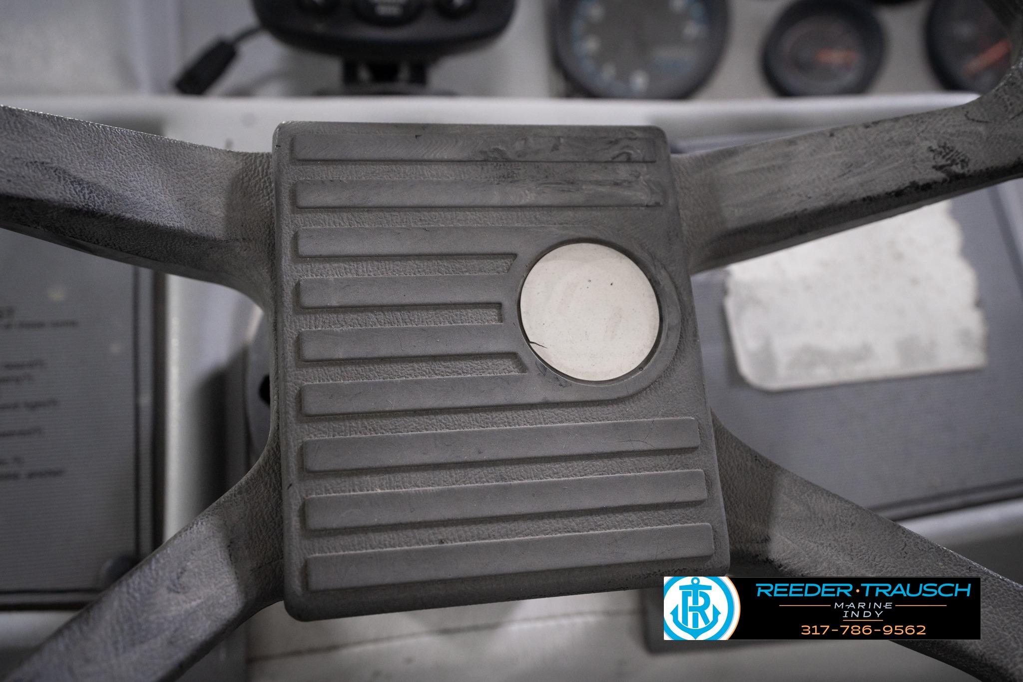 Steering wheel of a 1992 Godfrey Sweetwater boat with visible dashboard instruments.
