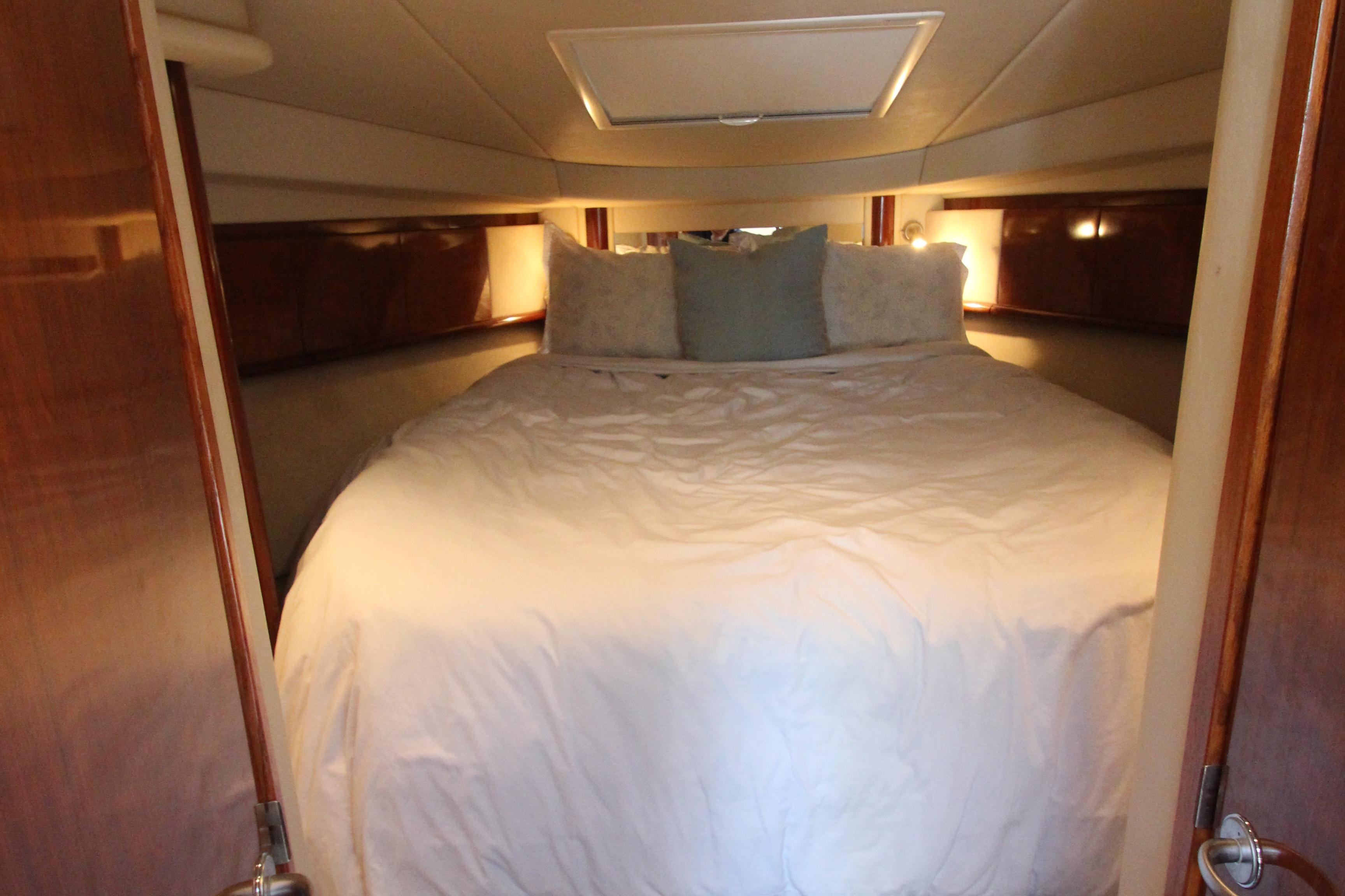 Luxurious cabin interior of 2004 Sea Ray 40 Sundancer yacht with cozy bedding.