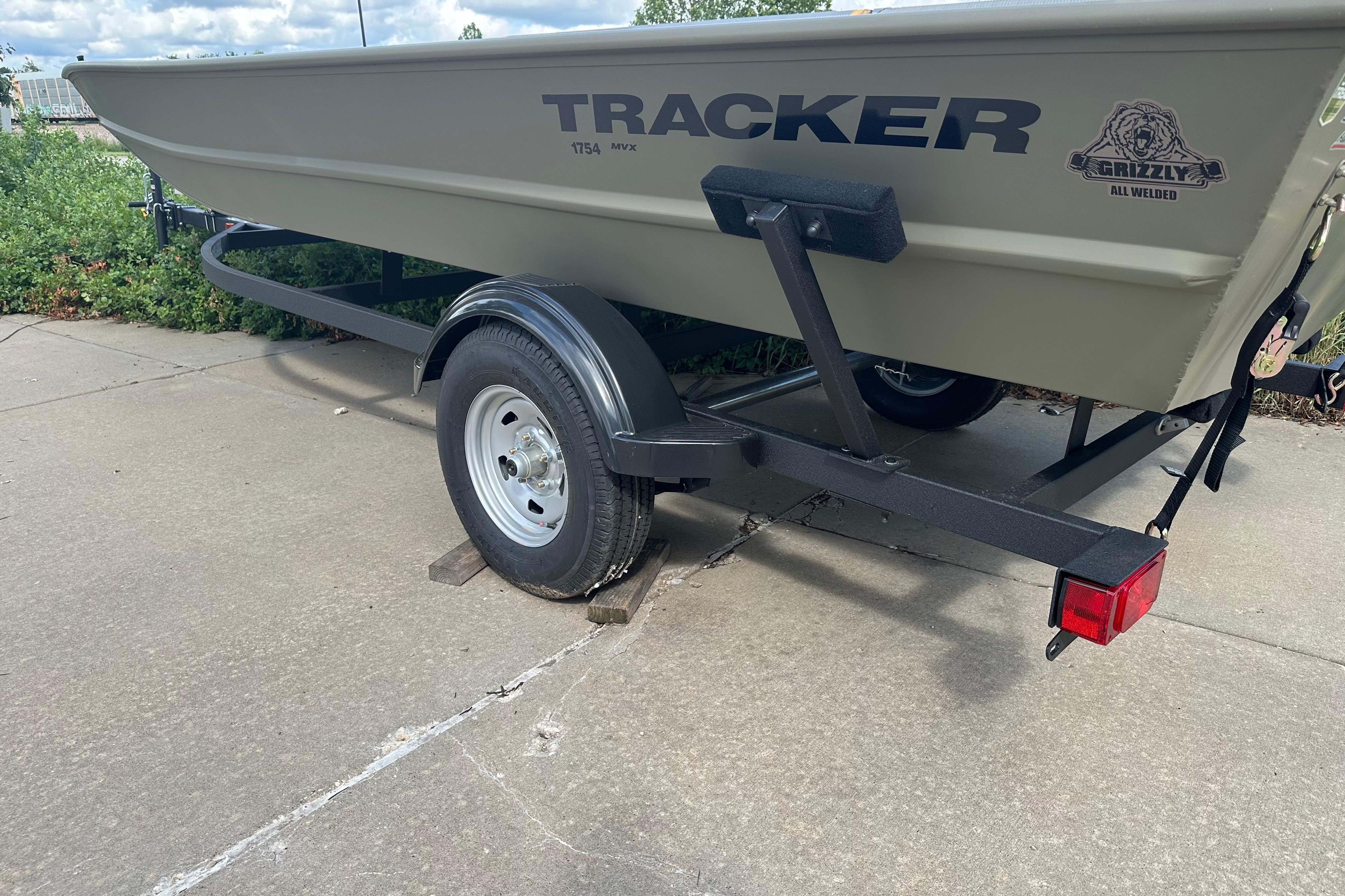 2026 Tracker Grizzly 1754 Utility boat on trailer, parked on concrete surface.