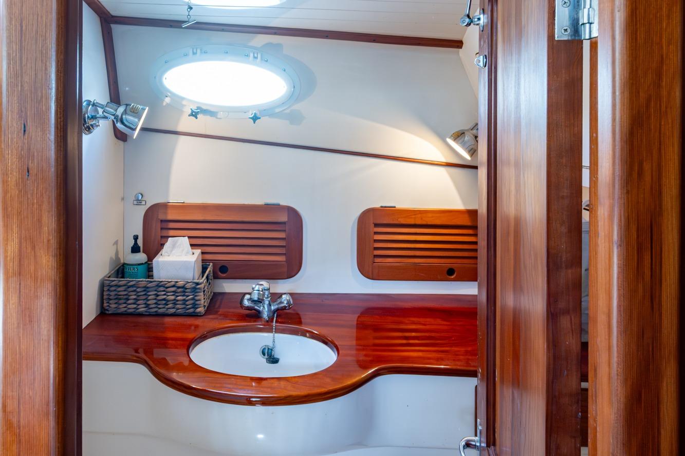 2001 Hinckley Picnic Boat Classic bathroom with wooden cabinetry and modern fixtures.