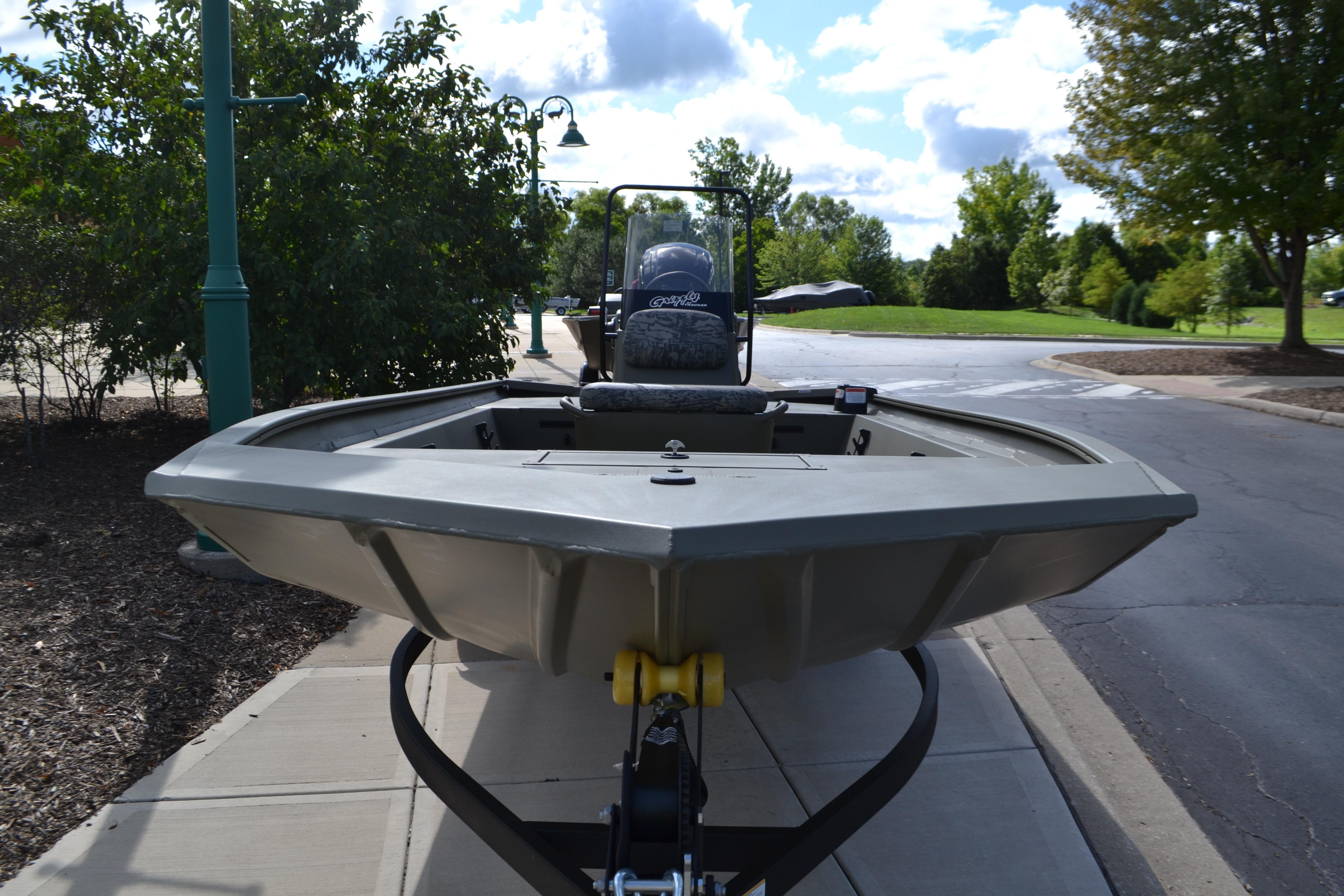 2026 Tracker Grizzly 1860 CC boat on trailer, parked on a sunny street.