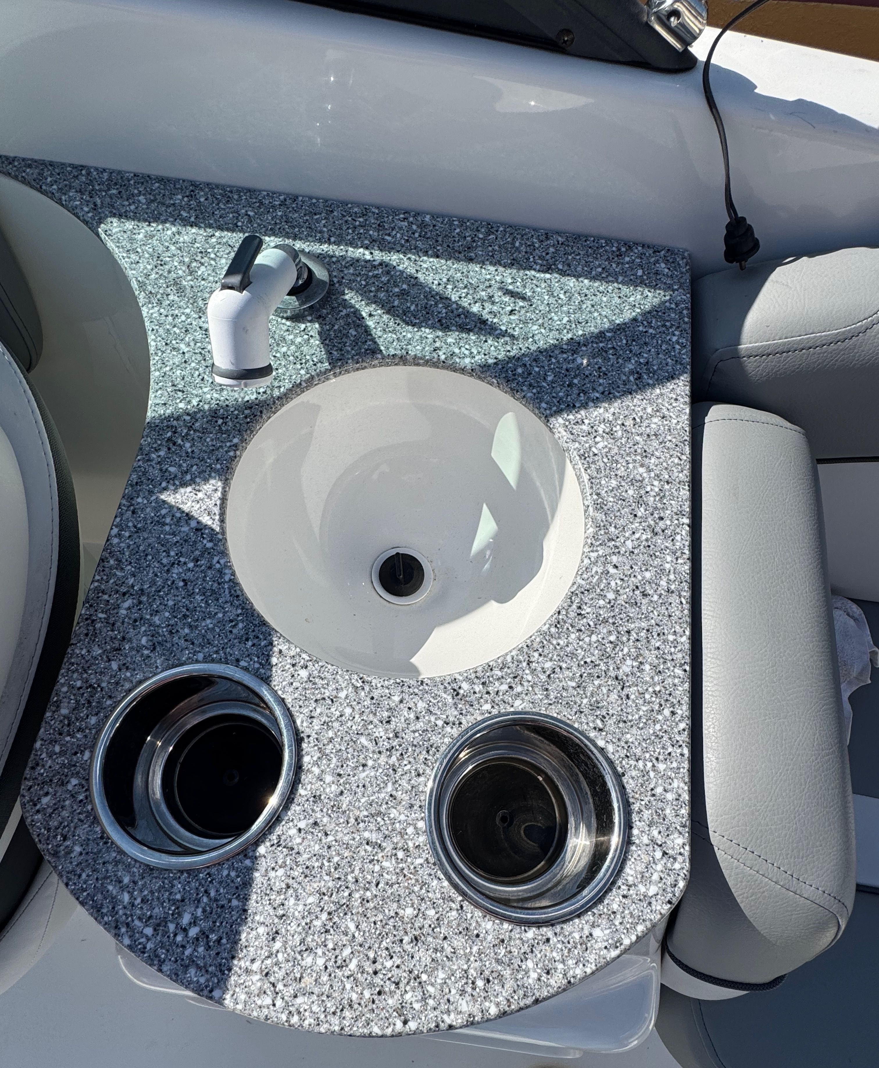 The image shows a gray granite sink on a boat with two cup holders.