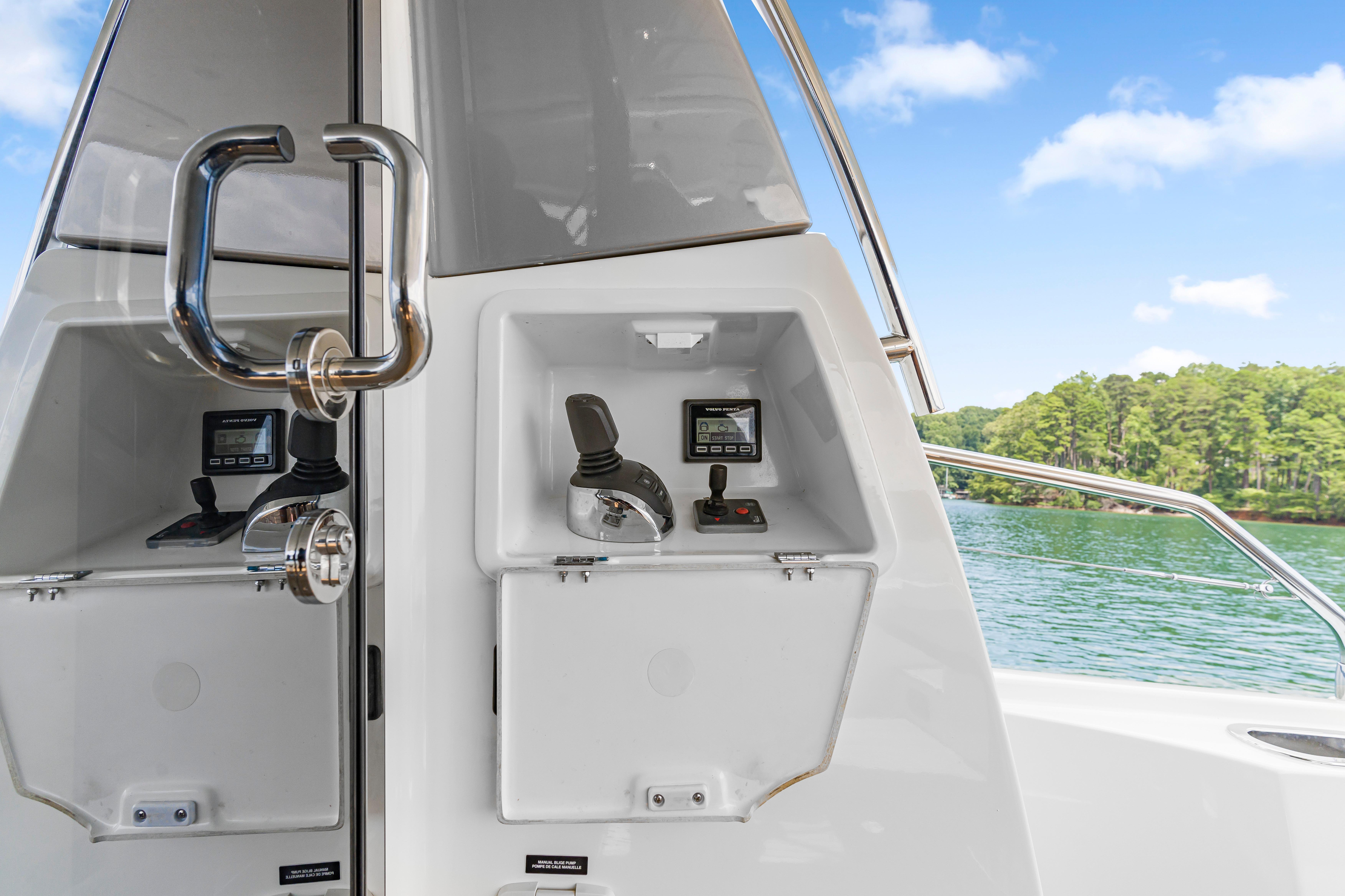 Control panel on a 2017 Prestige 500 yacht, overlooking serene waters and lush greenery.