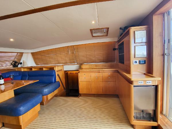 Interior of 2009 Catana 65 yacht with wooden cabinetry and blue seating.